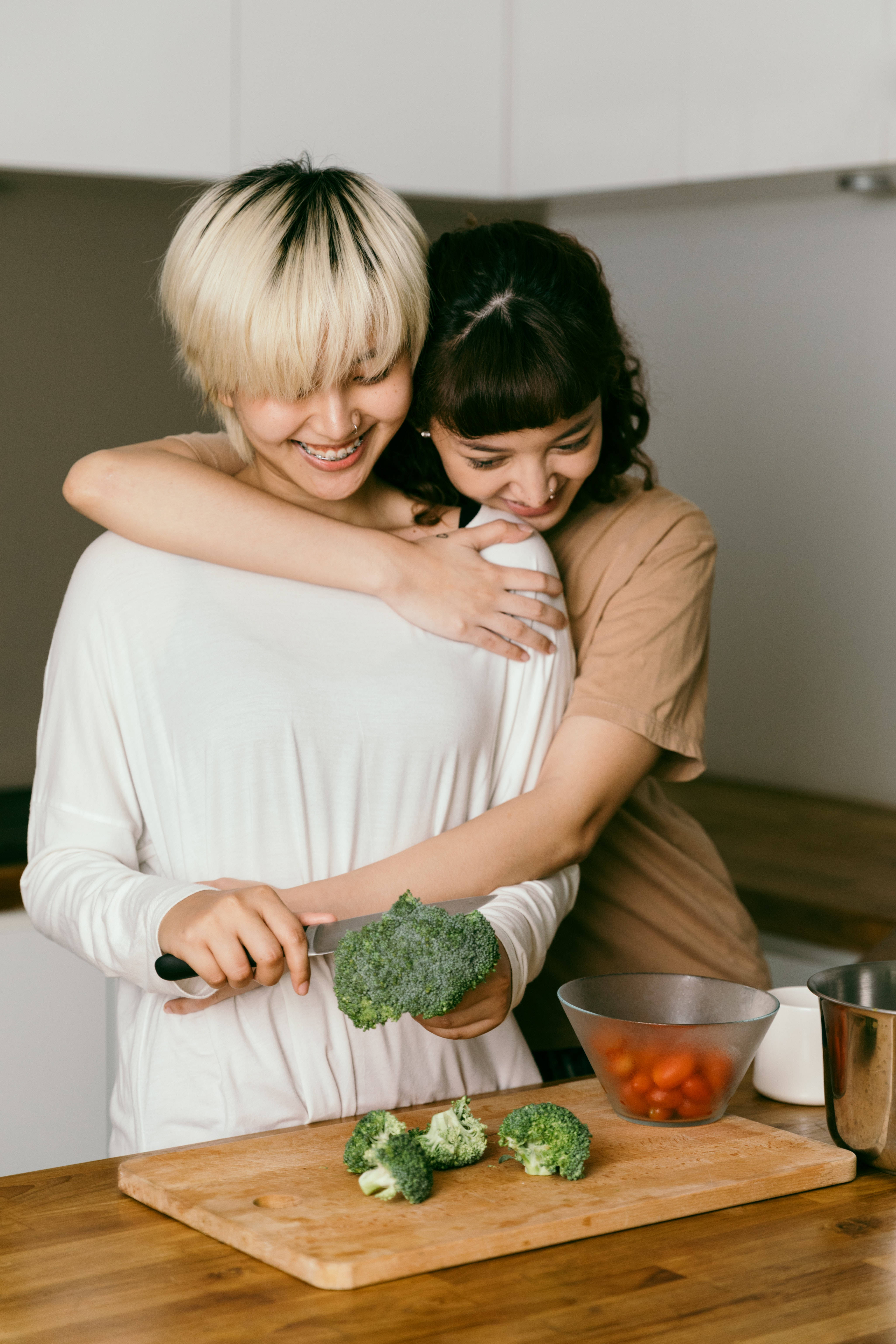 Lesbian Girl Back Hugs, wooden cutting board, bright kitchen, 5K Phone Wallpaper