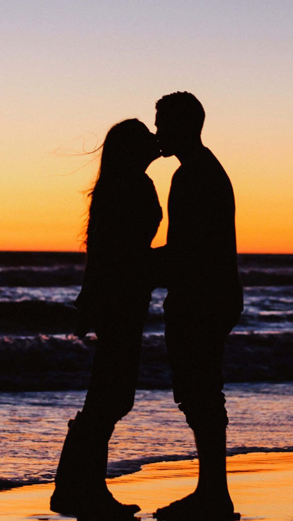 yellow sunset, silhouetted couple, beach, HD Phone Wallpaper