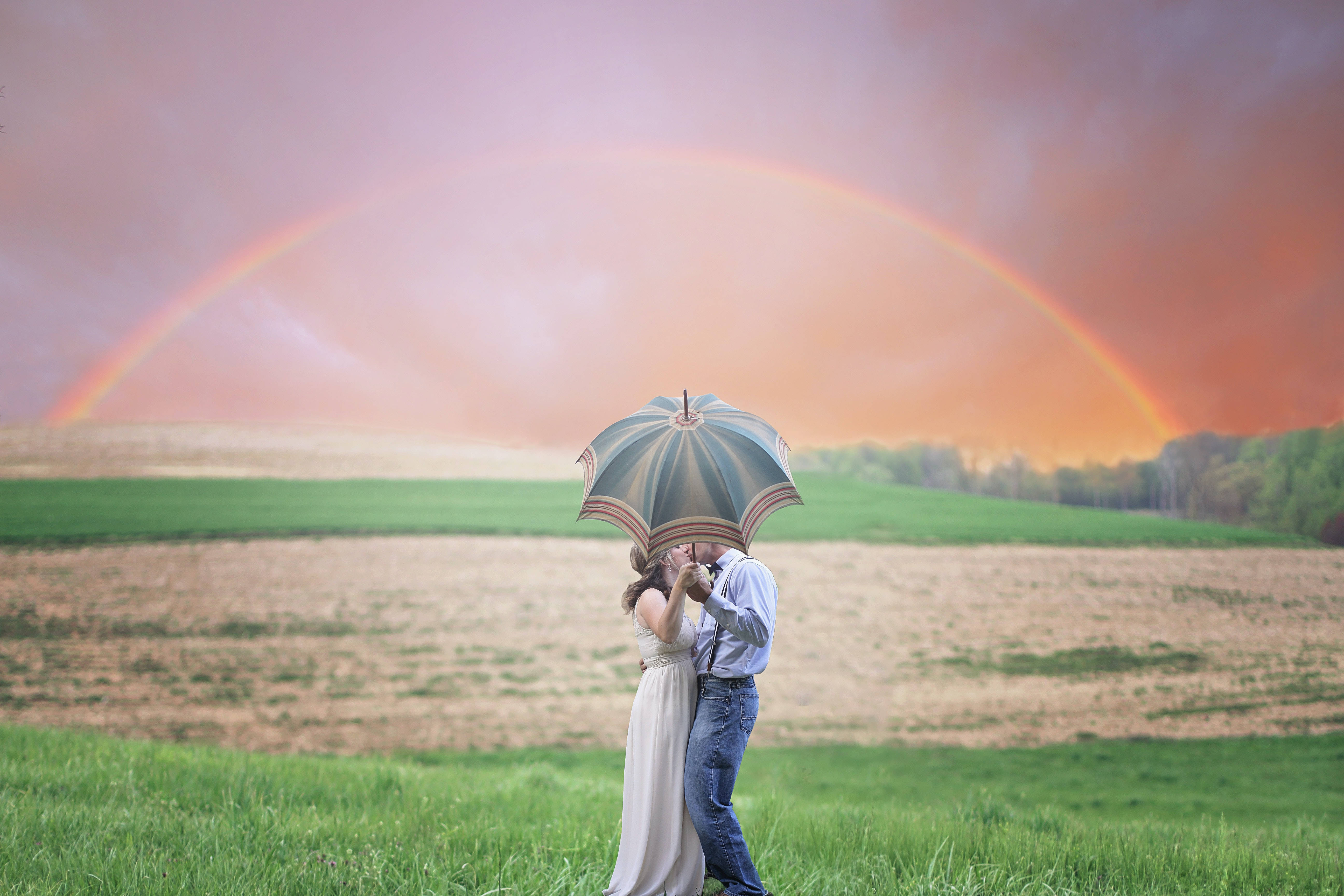 couple in love kissing under an umbrella, patterned umbrella, grassy field, 5K Desktop Wallpaper