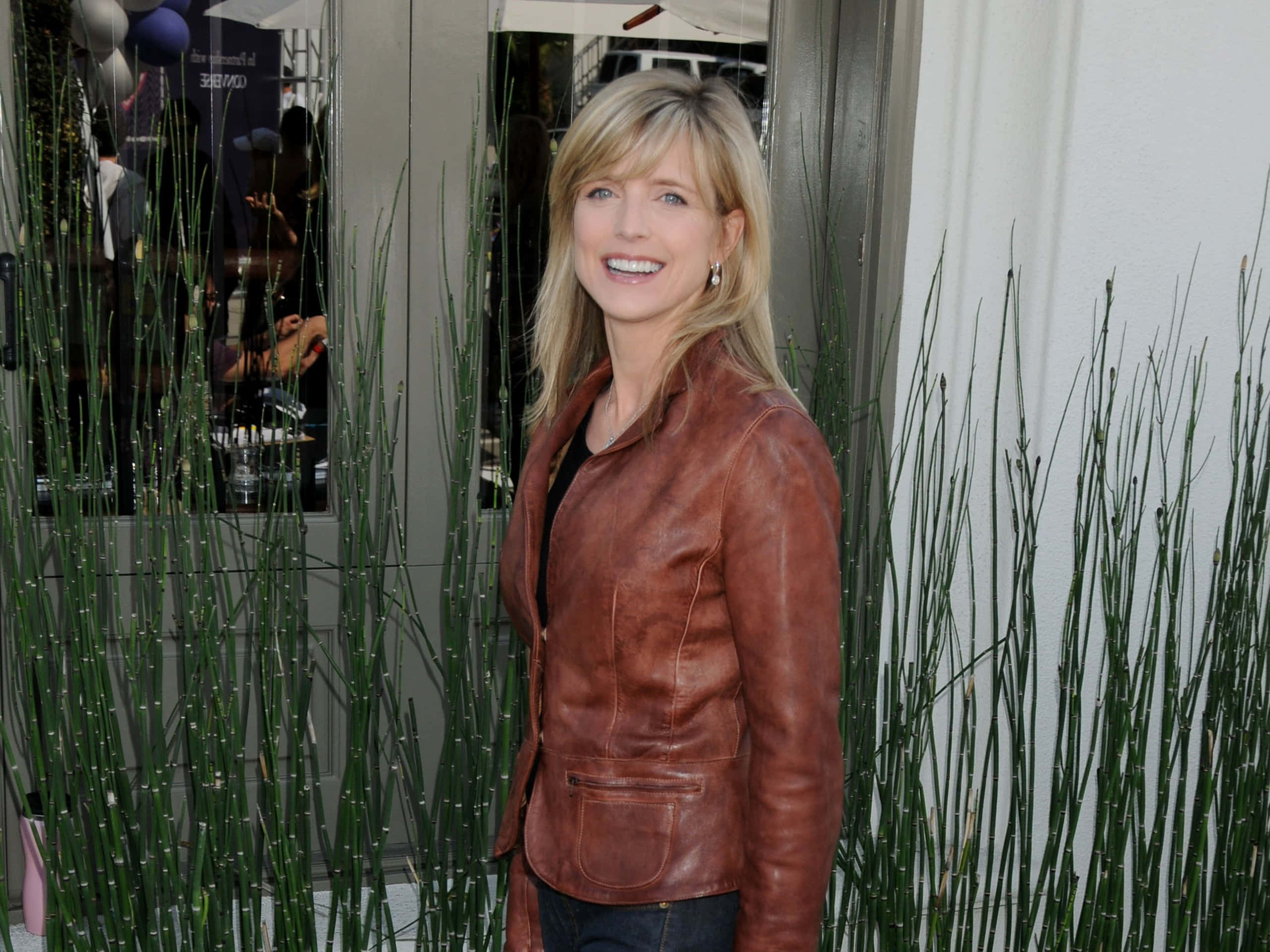 Courtney Thorne Smith, brown leather jacket, tall green reeds, 2K Desktop Wallpaper
