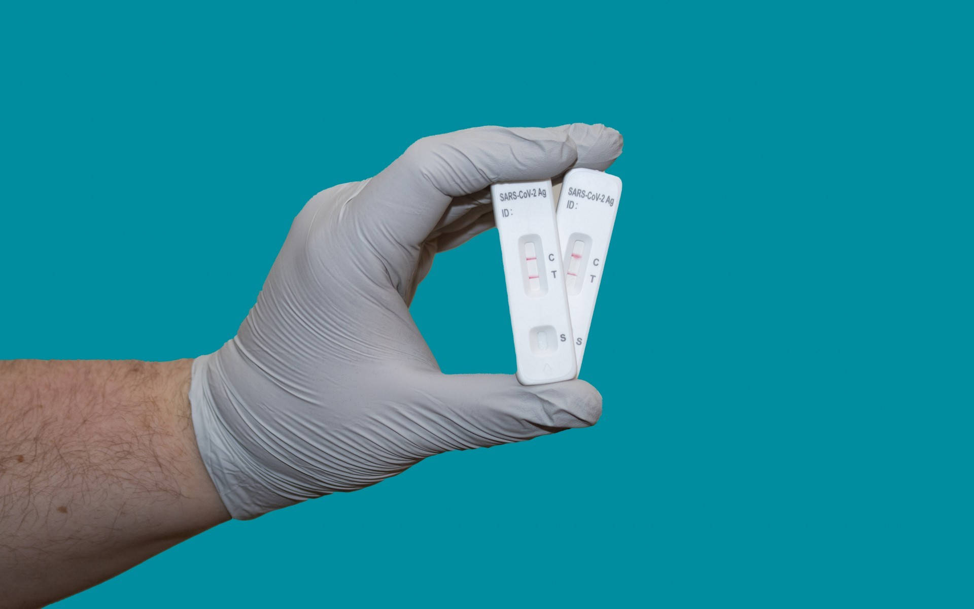 positive SARS-CoV-2 antigen test kits, gloved hand, solid teal background, Full HD Desktop Wallpaper