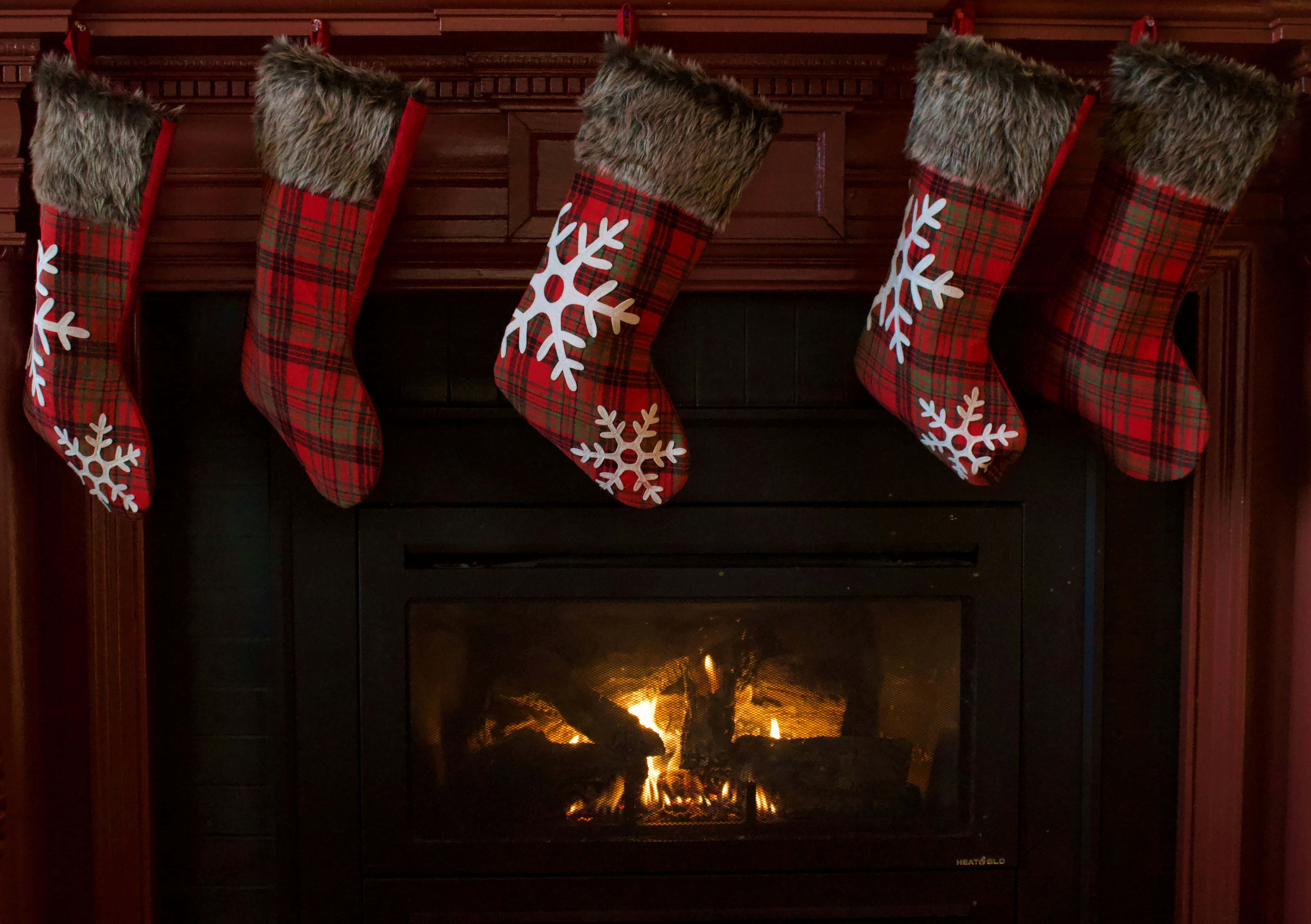 cozy christmas fireplace, red plaid Christmas stockings, white snowflakes, 5K Desktop Wallpaper