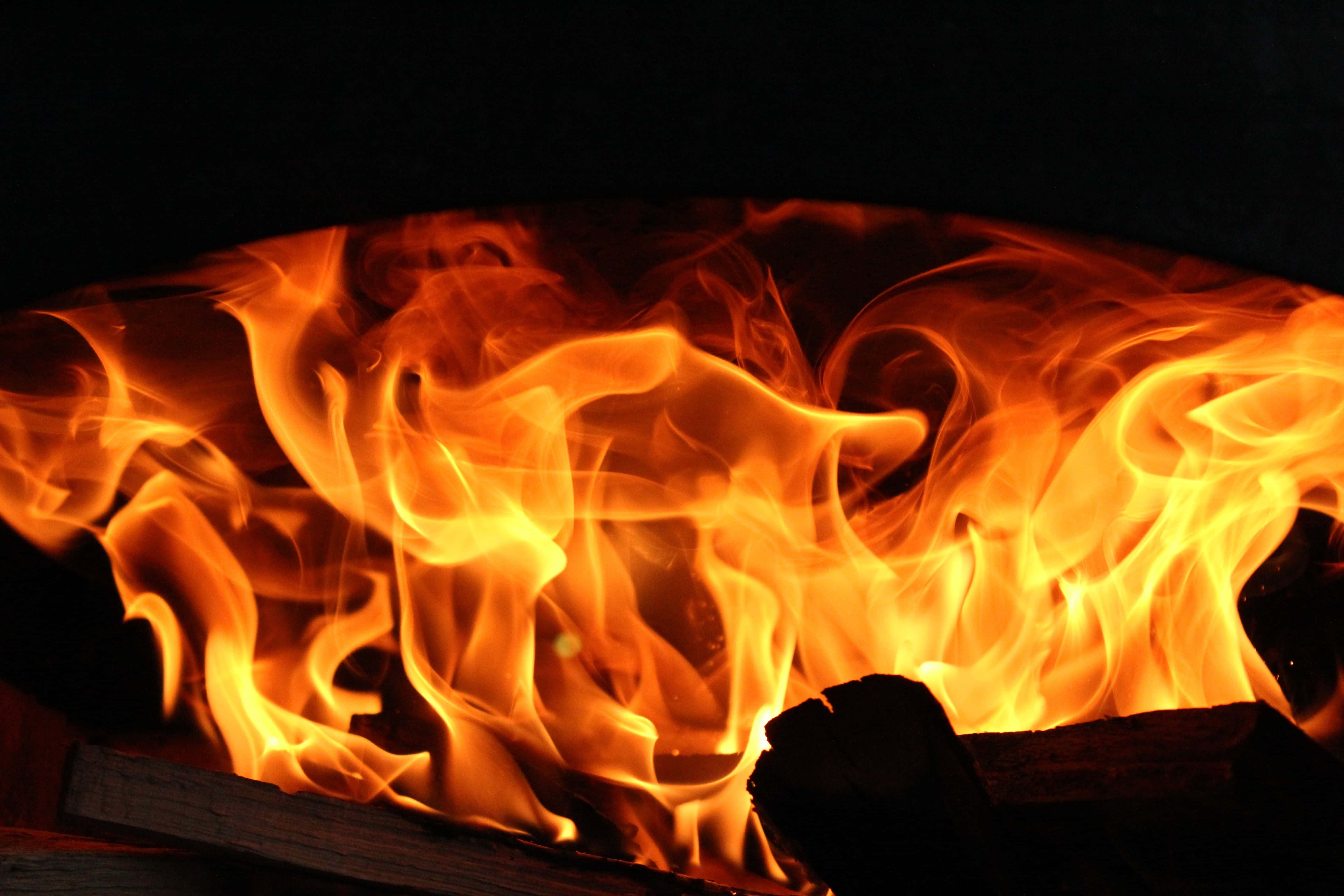 Cozy Fireplace Scene, orange and yellow flames, pitch black background, 5K Desktop Wallpaper