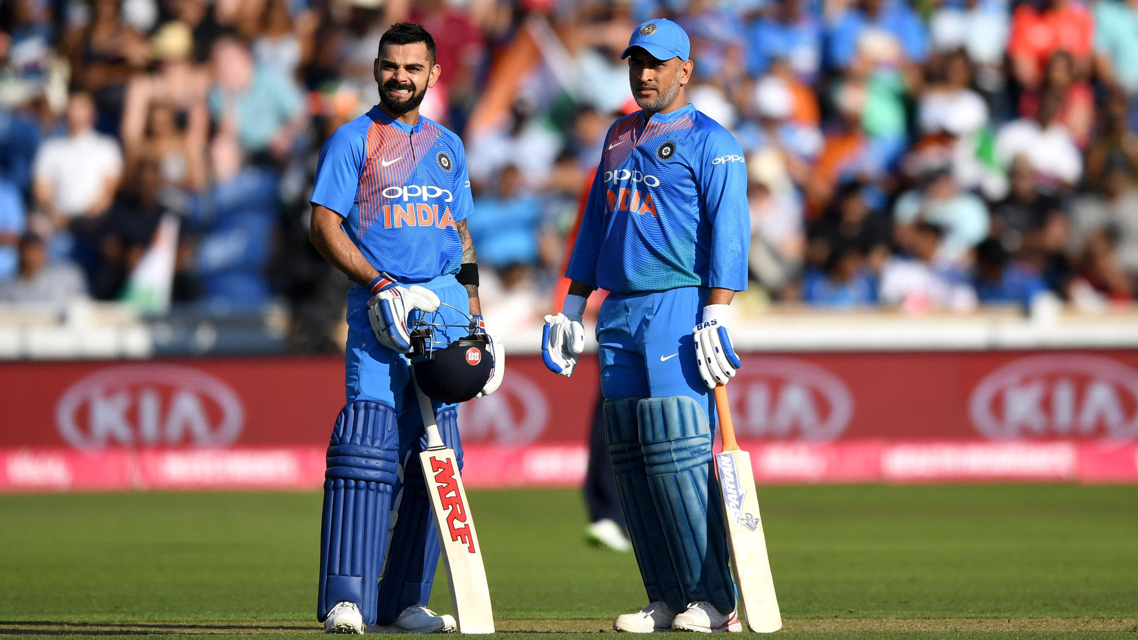 Indian cricket players, blue uniforms, sunlit green field, 4K Desktop Wallpaper
