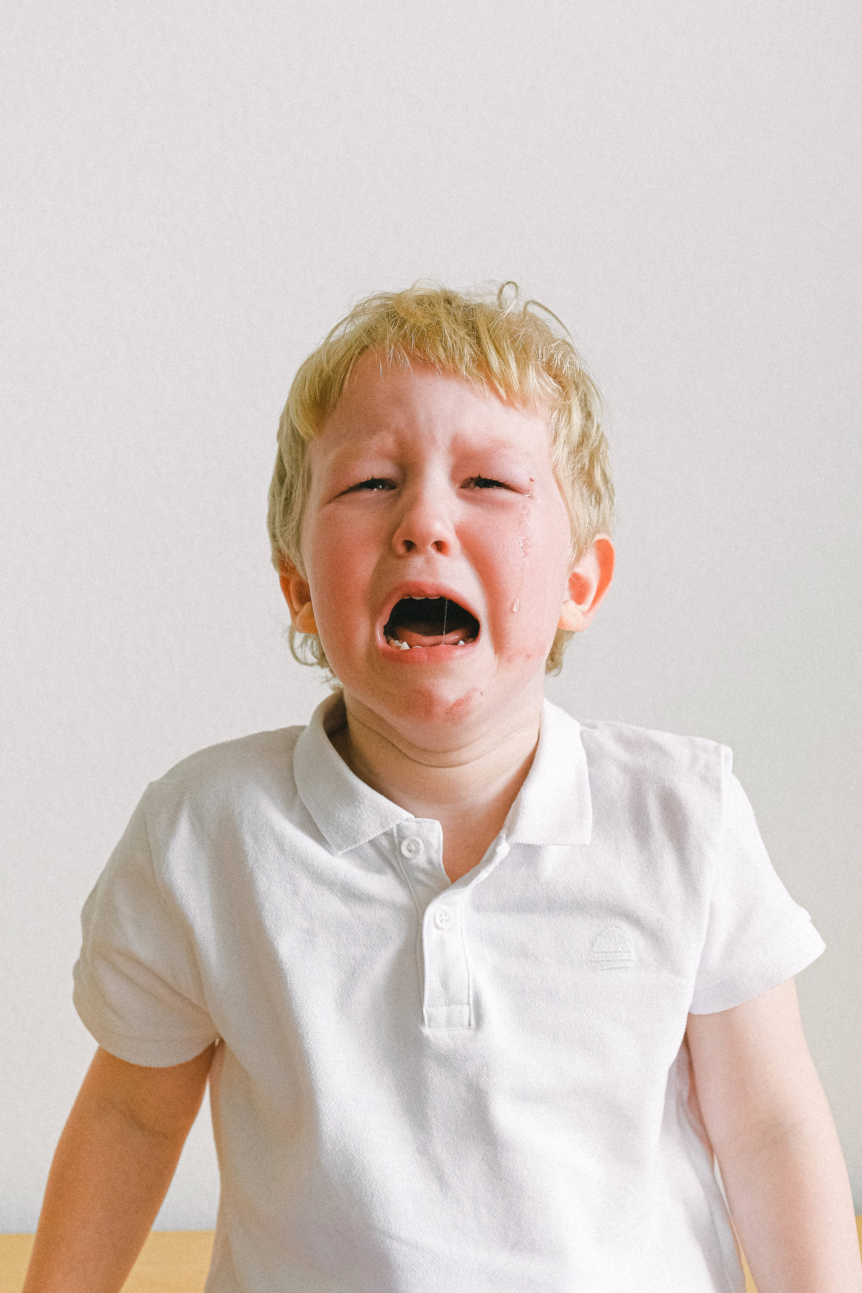 young blond boy, white polo shirt, eyes squeezed shut, 5K Phone Wallpaper