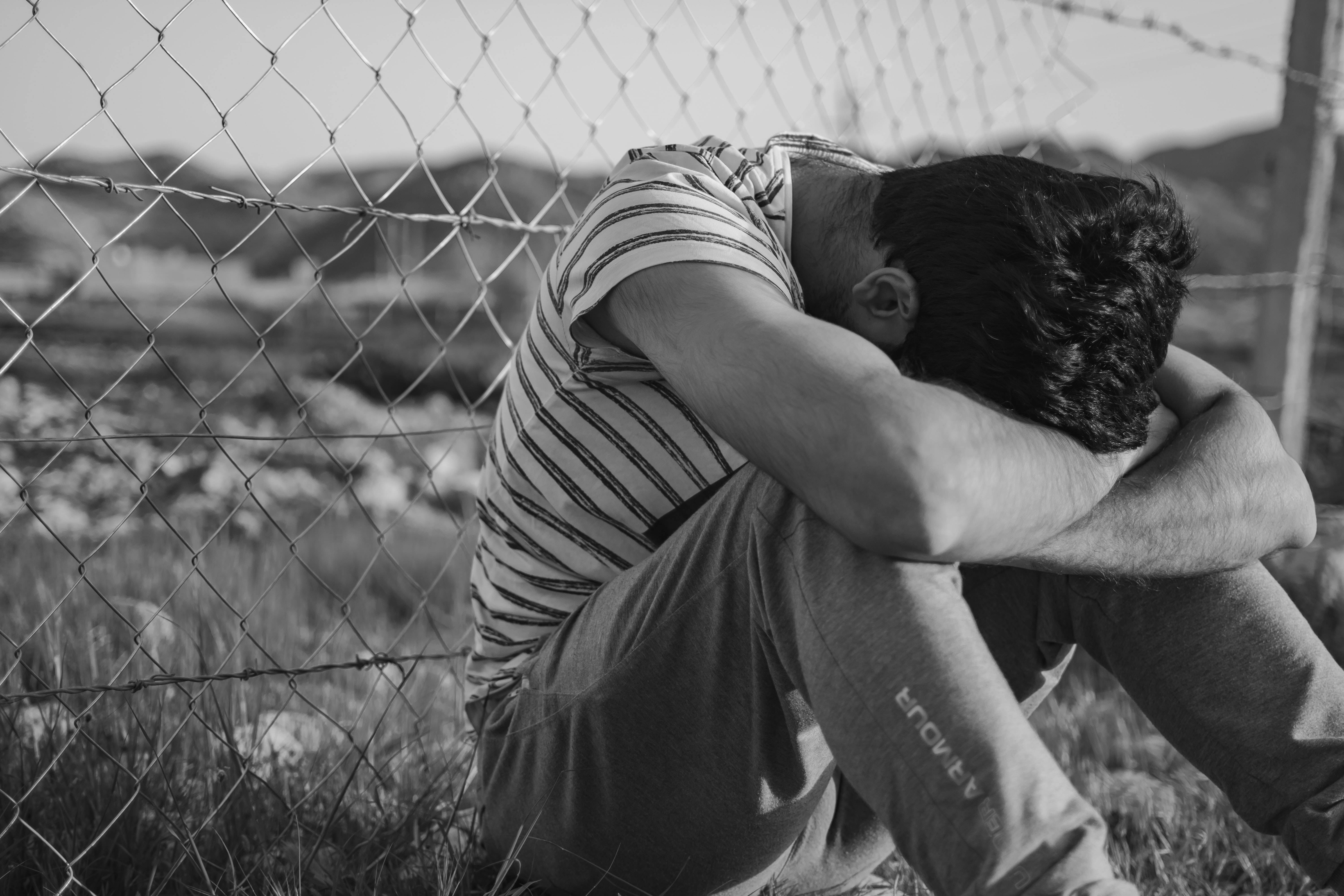 Downcast Crying Sad Boy, chain-link fence, desolate field, 5K Desktop Wallpaper