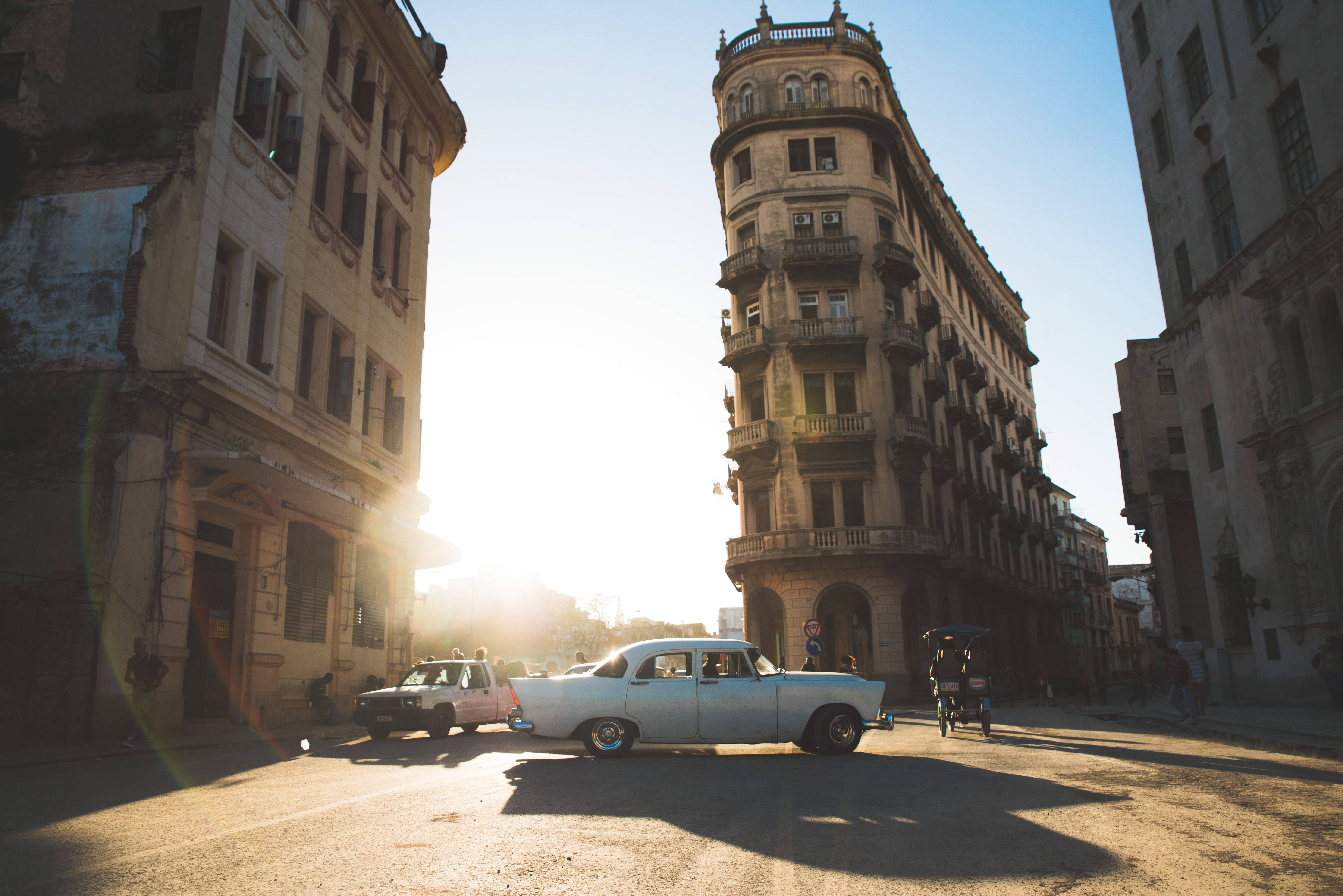 vintage white car, sun-drenched street, weathered colonial buildings, 5K Desktop Wallpaper