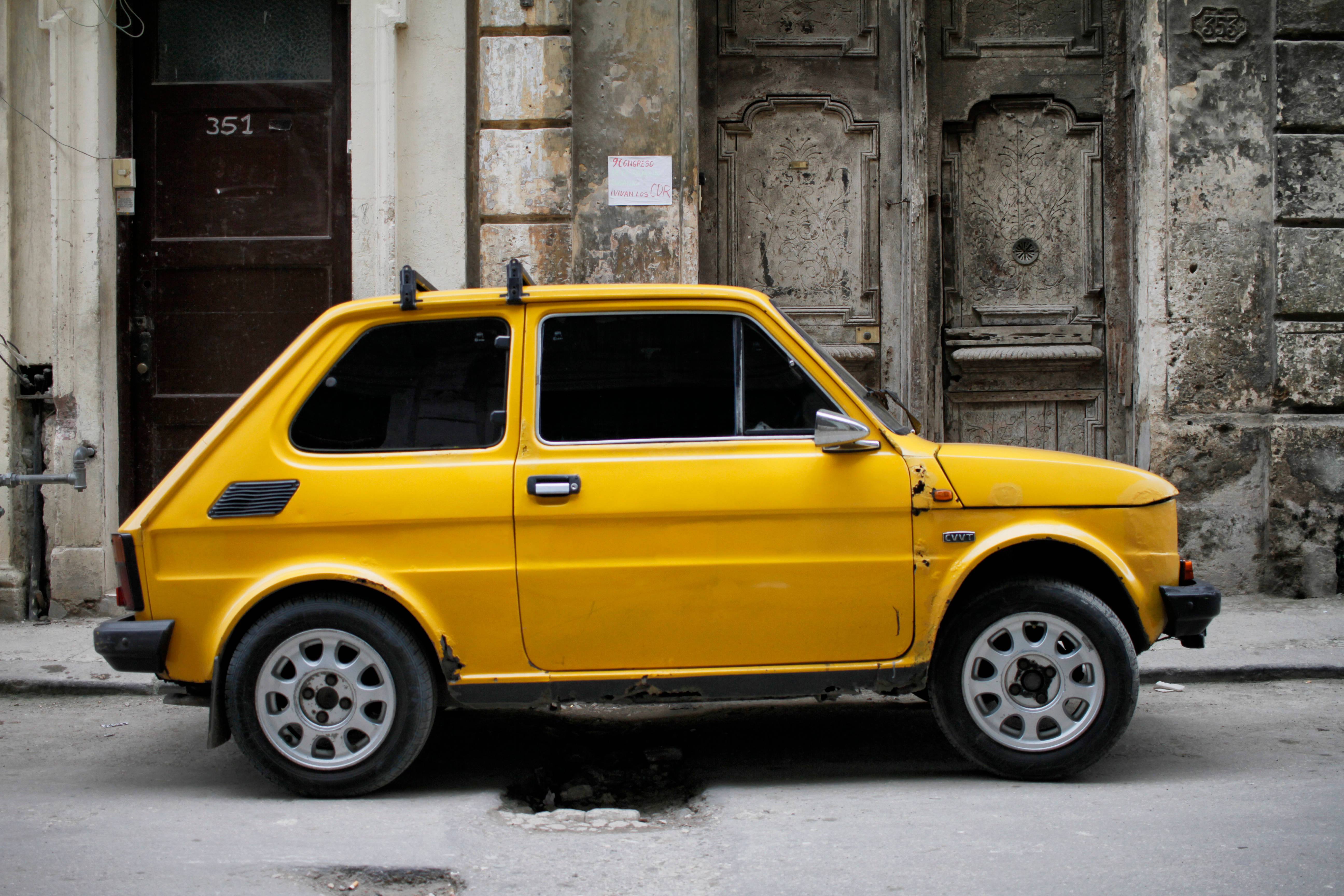 yellow Fiat 126, Cuba, weathered urban street, 5K Desktop Wallpaper