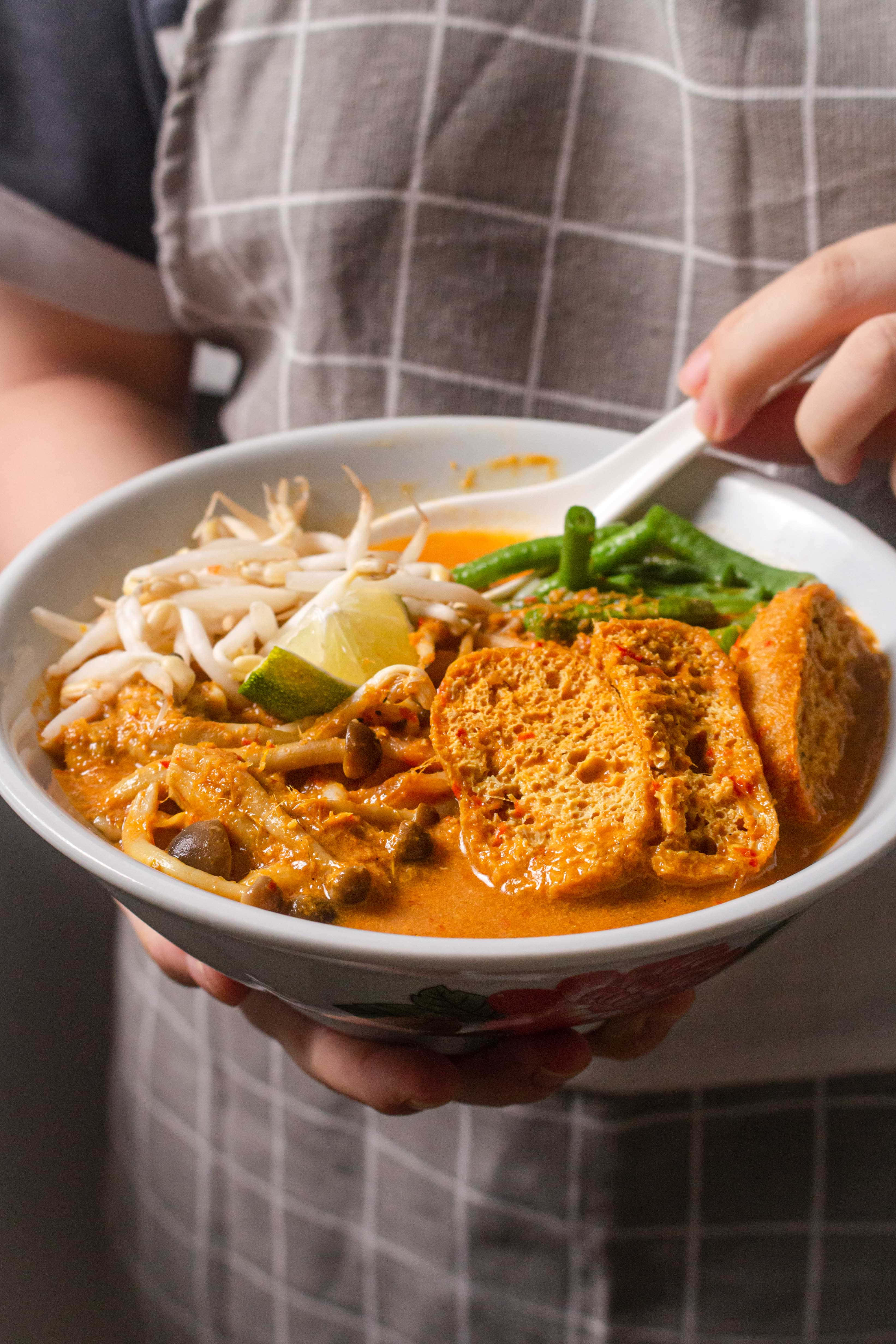 vegan curry laksa, checkered apron, steaming bowl, 4K Phone Wallpaper