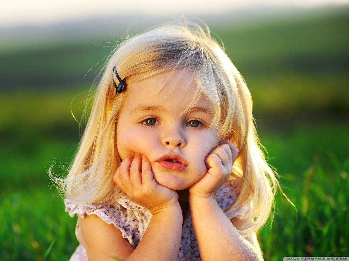 blonde baby girl, sunlit grassy field, soft blurred background, SD Desktop Wallpaper