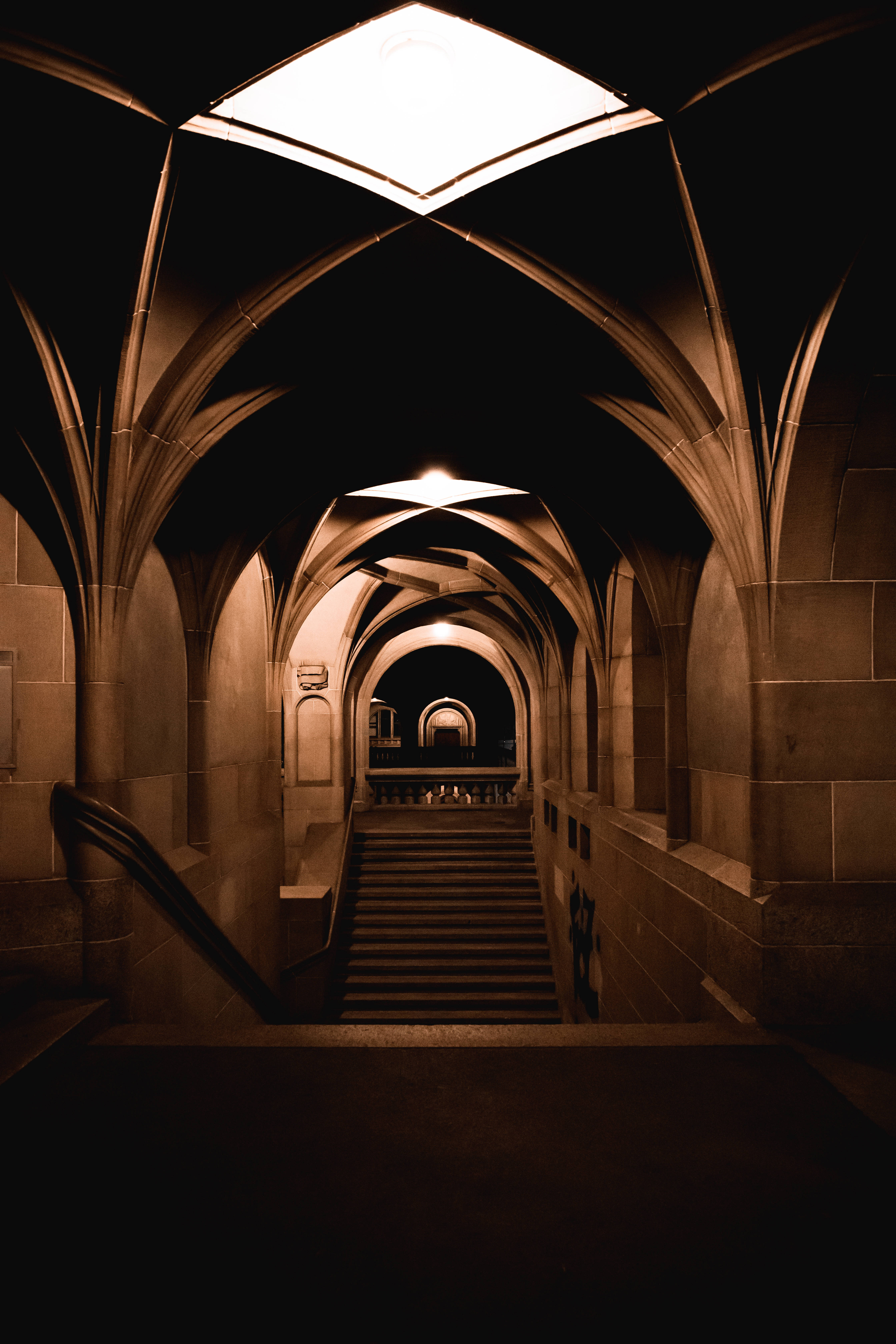 Gothic arches, stone staircase, warm overhead lights, 5K Phone Wallpaper