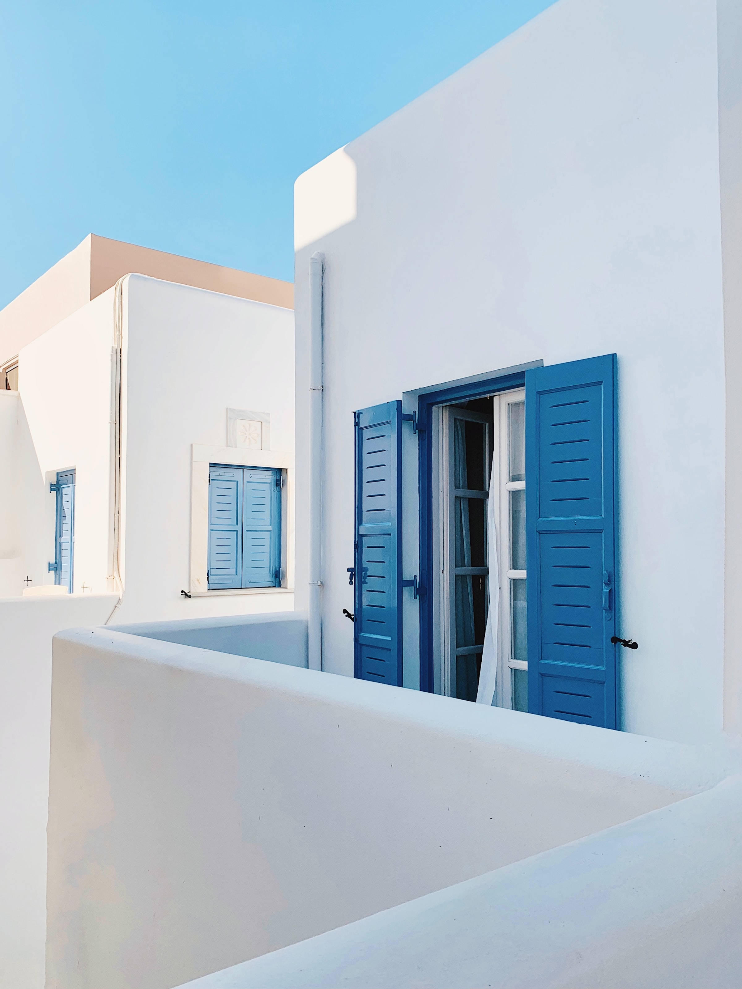 Cycladic style house, vivid blue shutters, bright white Greek buildings, 2K Phone Wallpaper