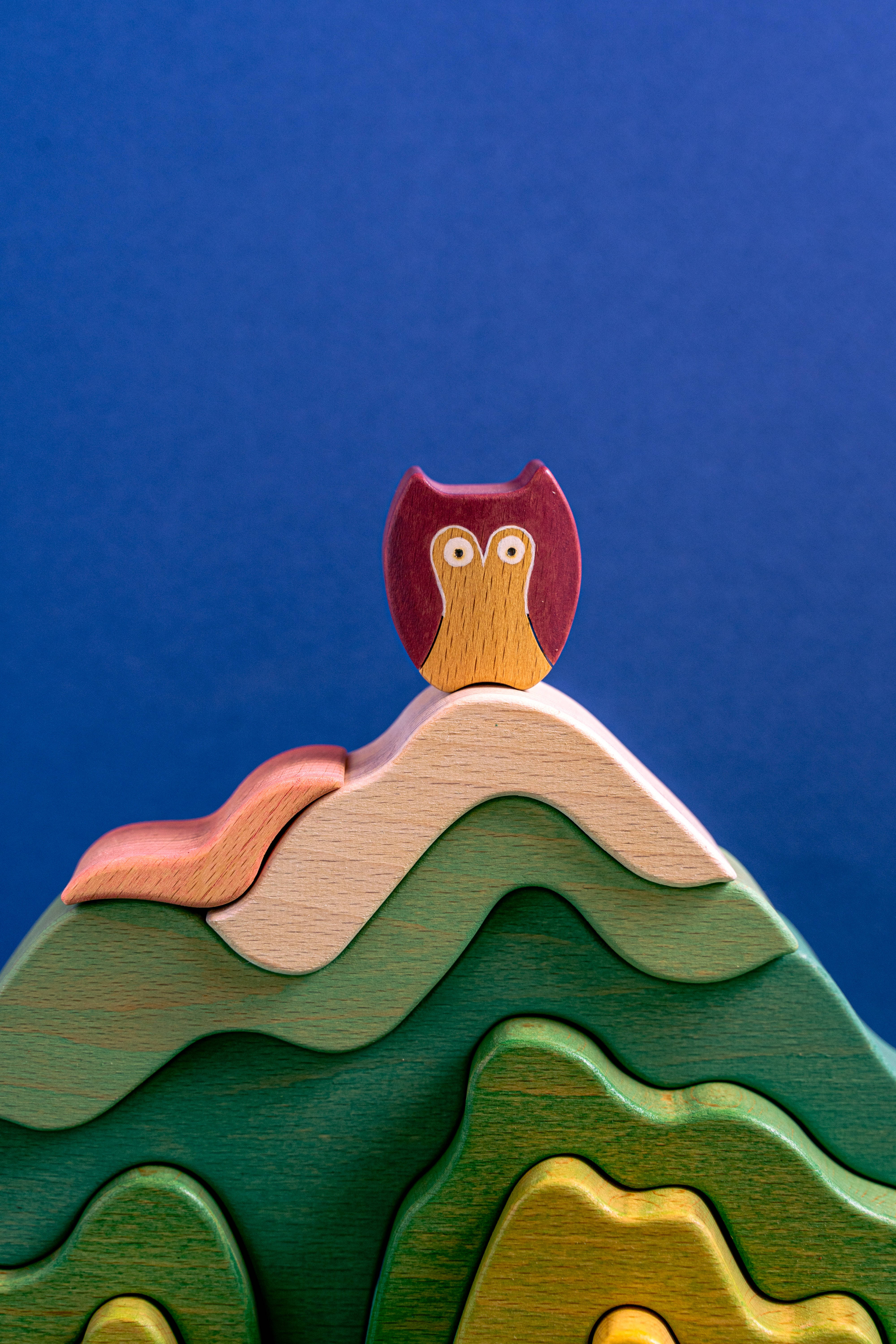 cute blue owl toy, wooden owl figurine, colorful layered mountain puzzle, 5K Phone Wallpaper