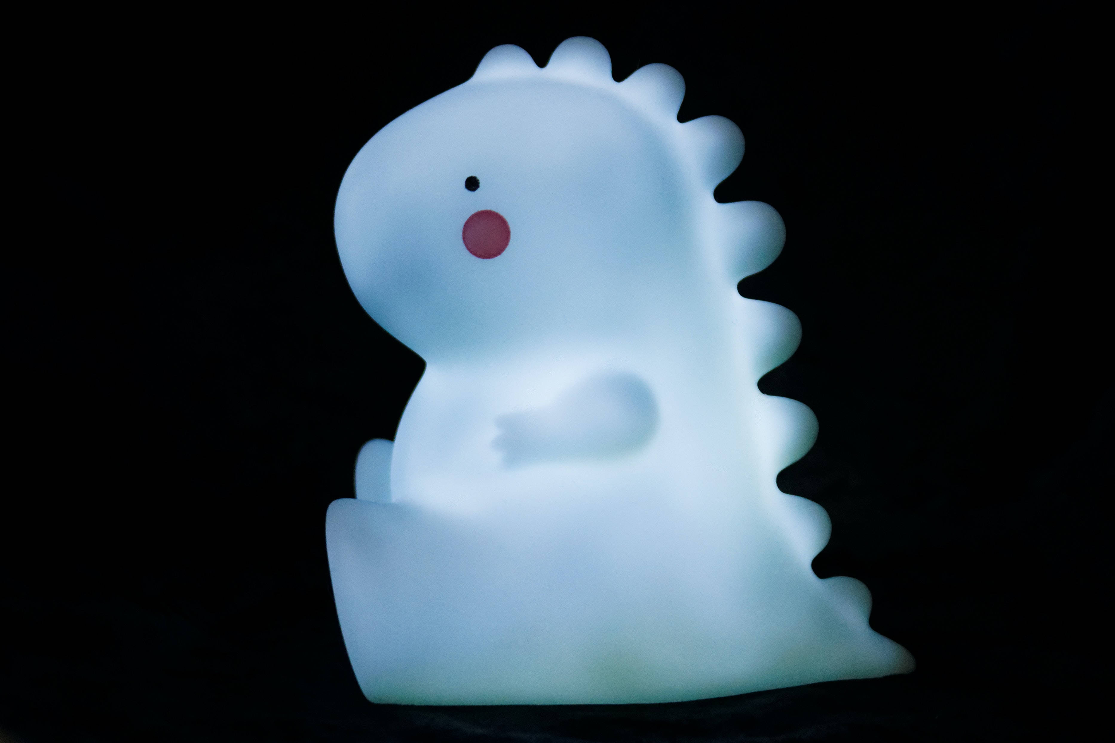 glowing light blue dinosaur lamp, red cheek, spiky back, 2K Desktop Wallpaper