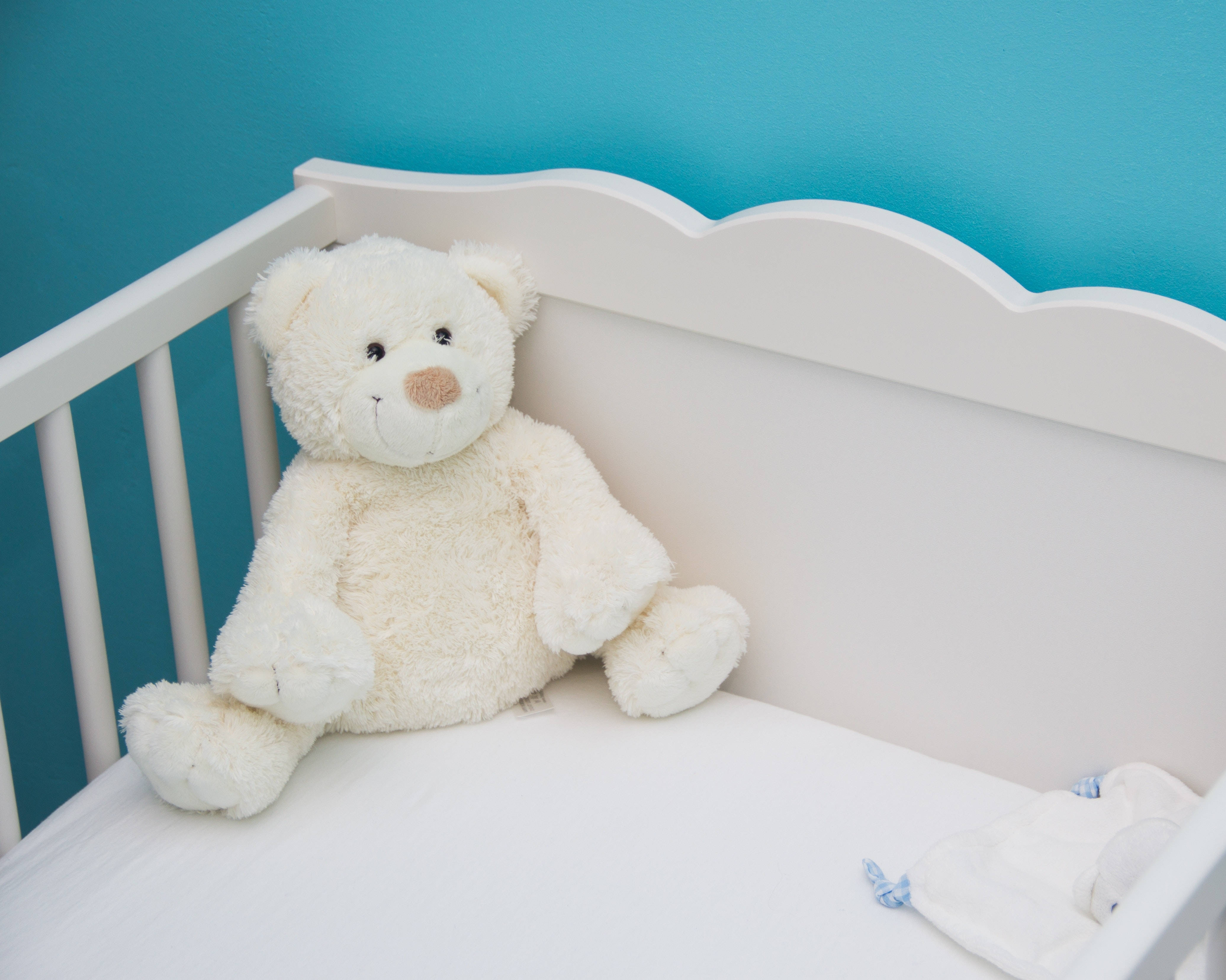 white crib, vibrant teal wall, soft cream teddy bear, 4K Desktop Wallpaper
