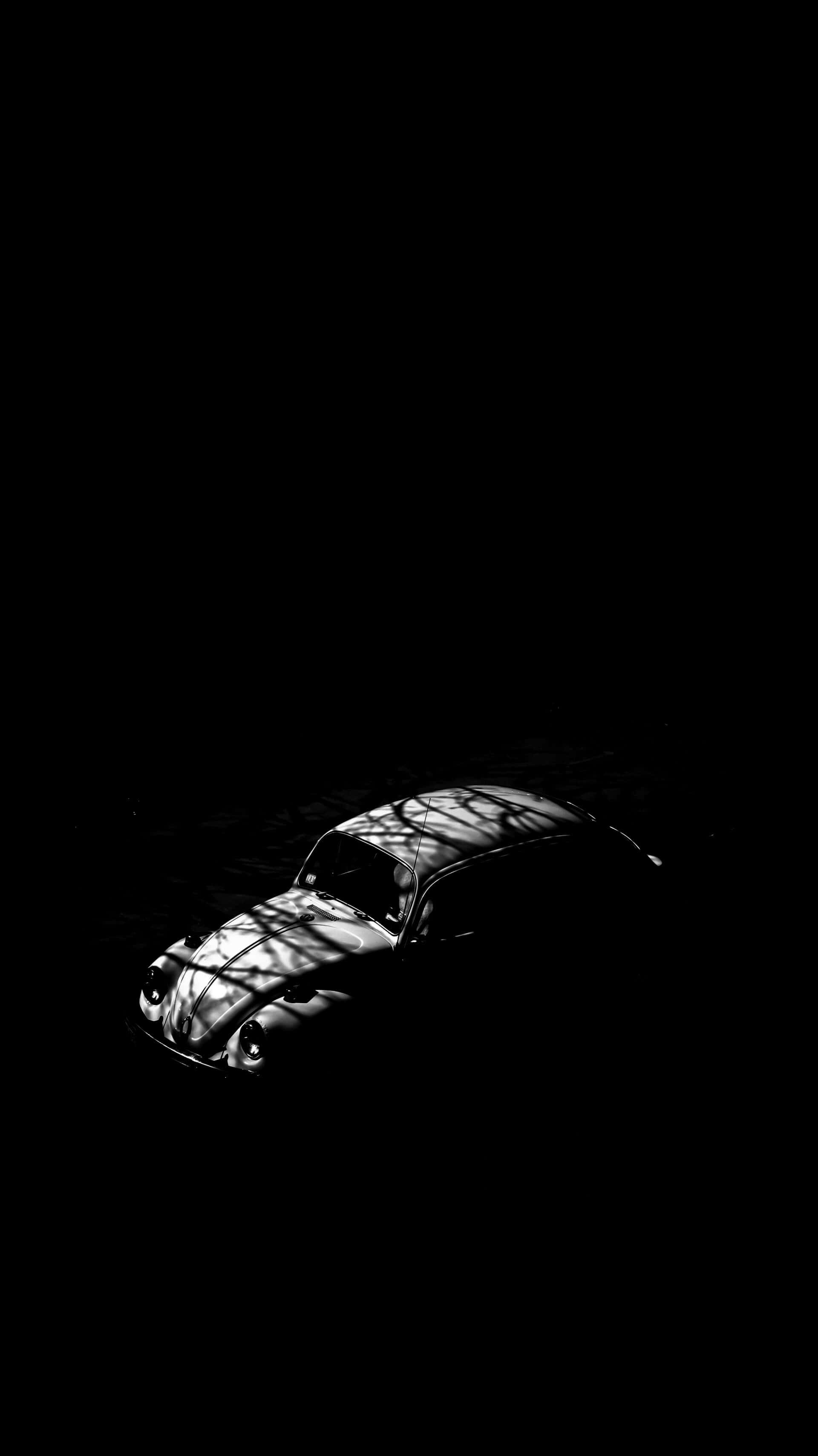 vintage Volkswagen Beetle, stark tree shadows, pitch-black background, 2K Phone Wallpaper