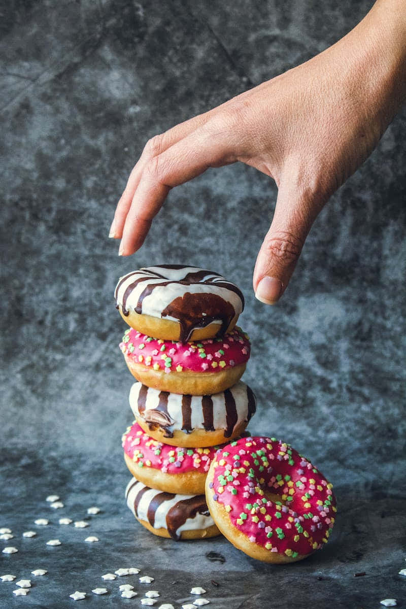 chocolate-drizzled donut, pink-frosted and striped donuts, dark textured backdrop, SD Phone Wallpaper