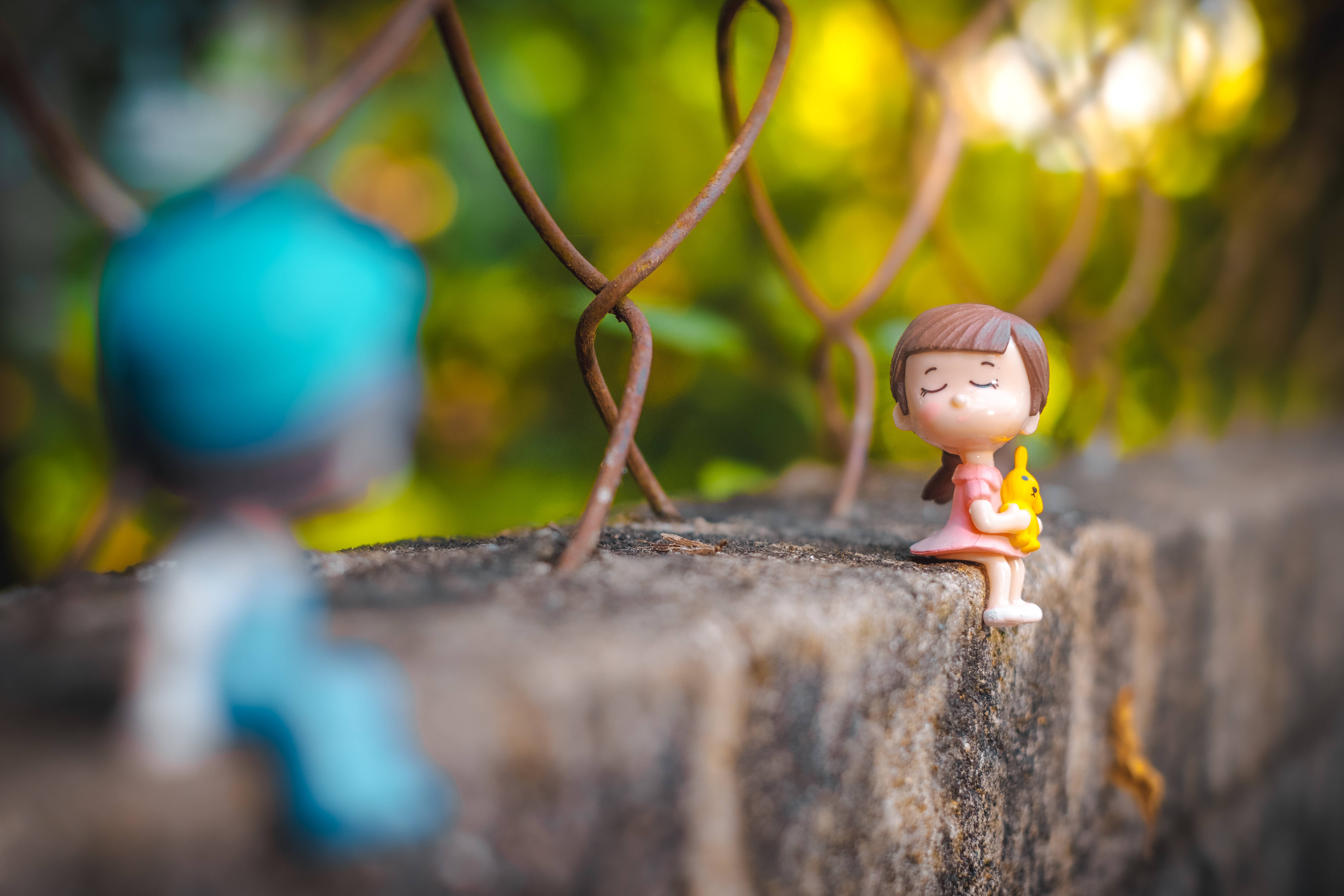 mini cute doll couple, stone wall, rusty chain-link fence, 5K Desktop Wallpaper