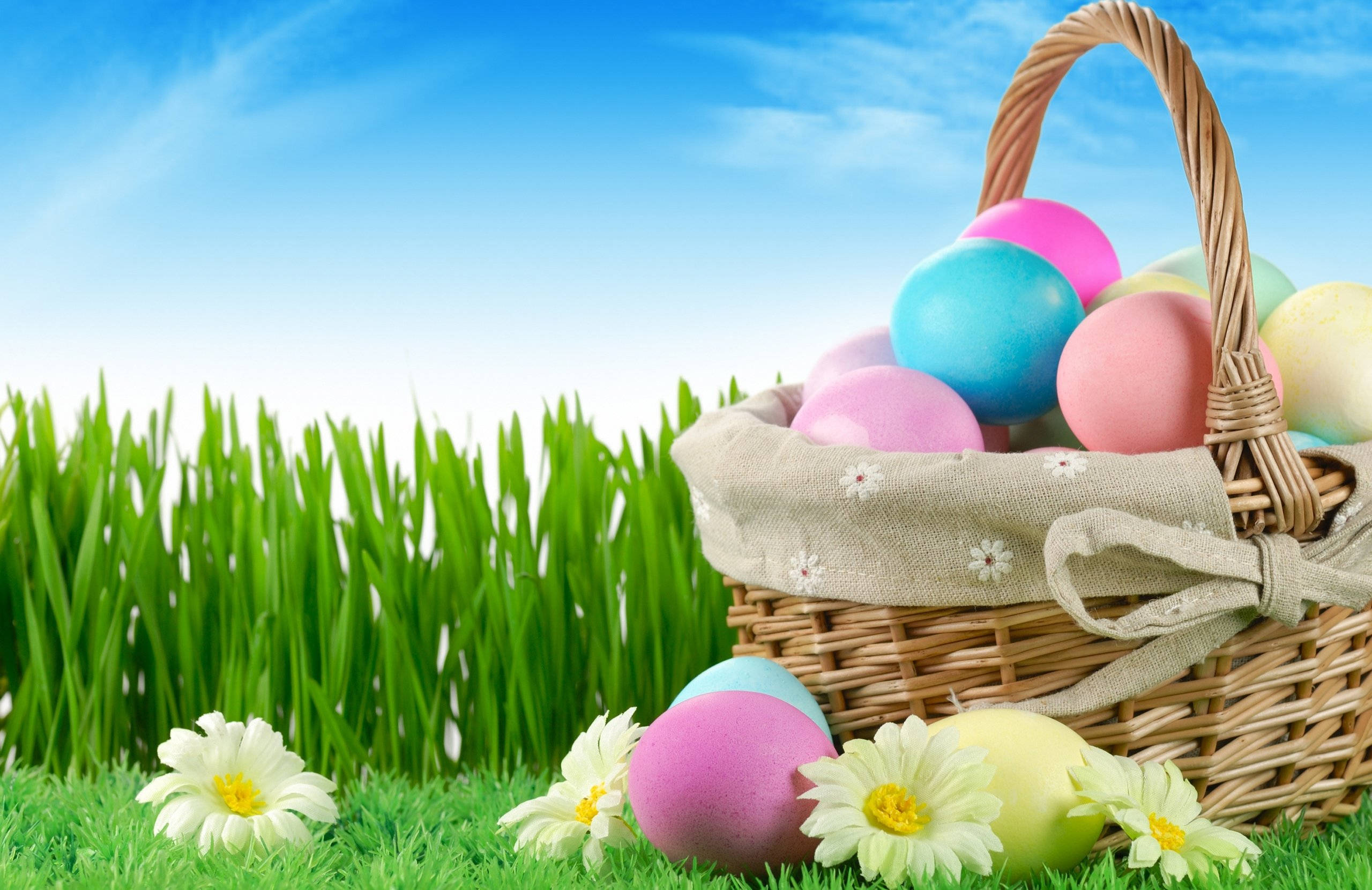 wicker basket, colorful Easter eggs, vibrant green grass, 2K Desktop Wallpaper
