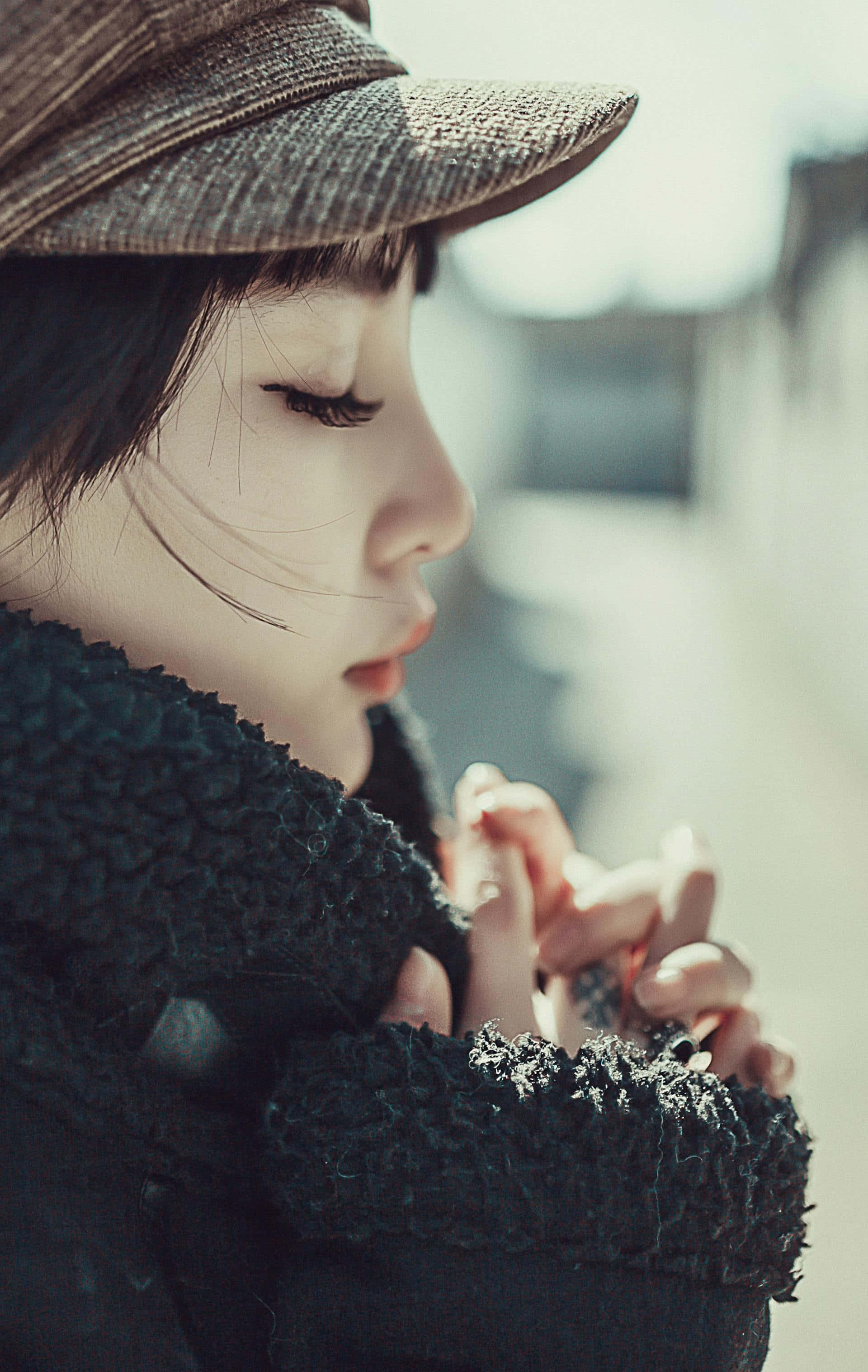 contemplative girl with hat, textured brown cap, dark fuzzy coat, 2K Phone Wallpaper