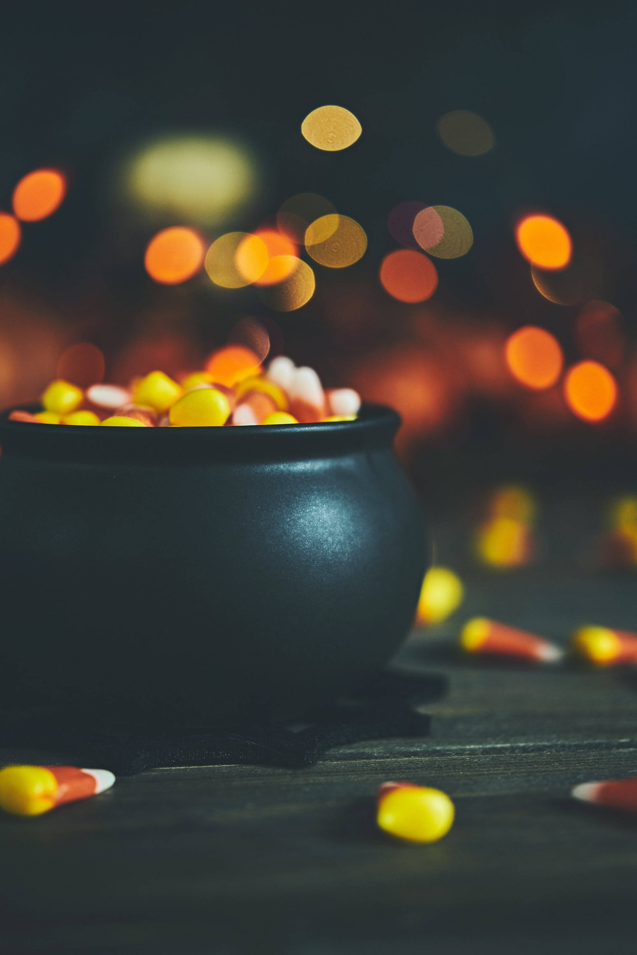 black cauldron, candy corn, dark wooden surface, 2K Phone Wallpaper