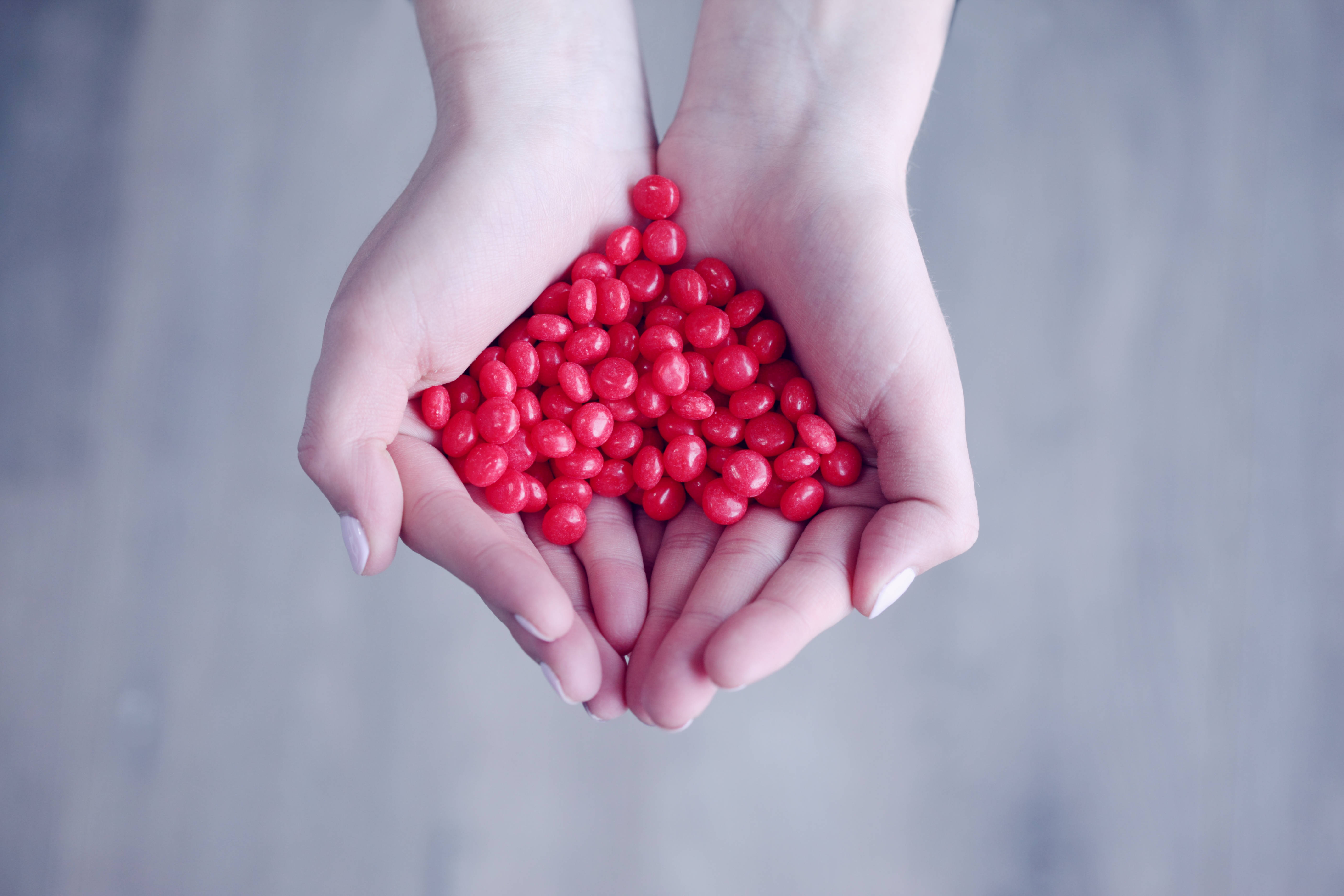 cute heart, glossy red candies, soft gray wooden background, 5K Desktop Wallpaper
