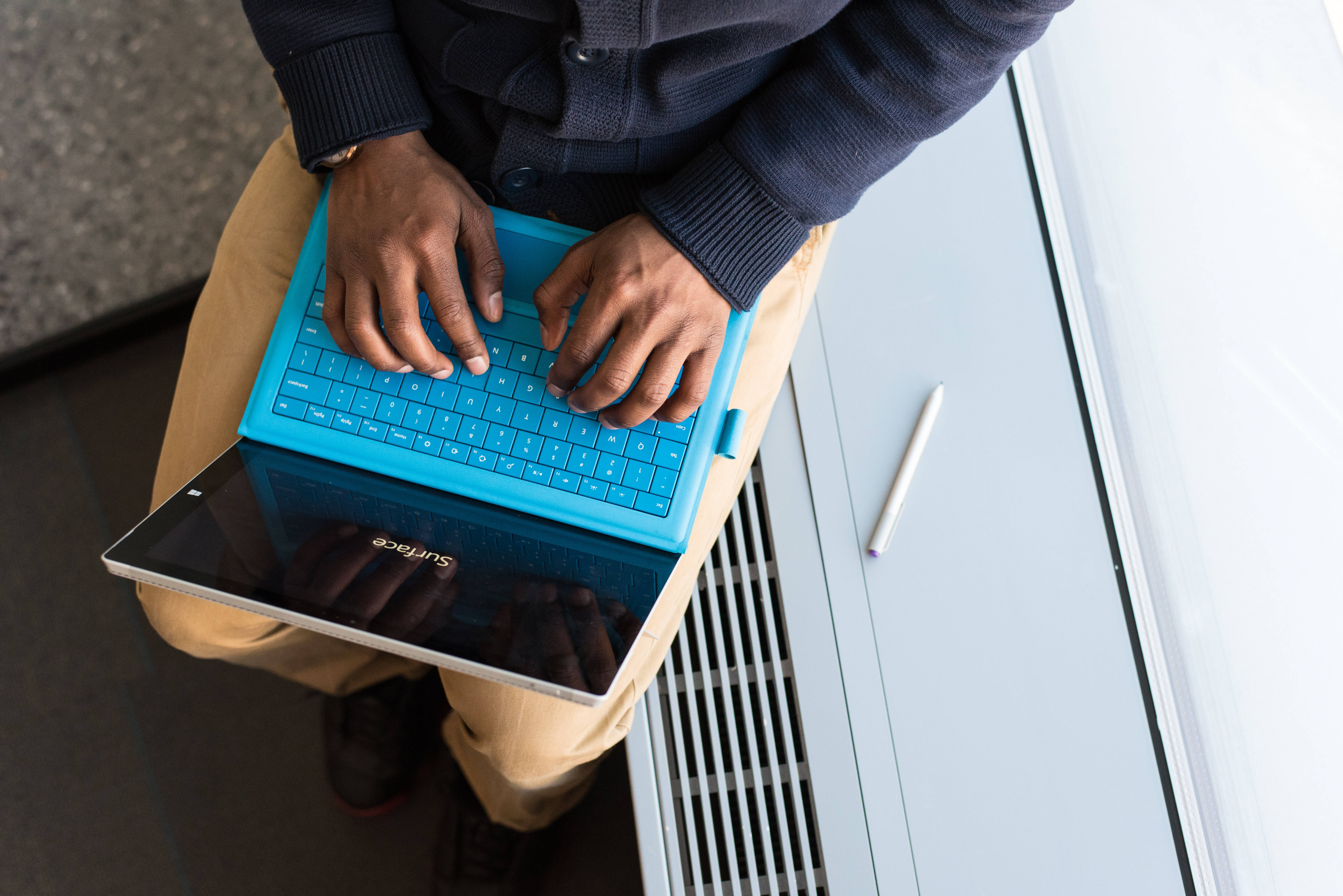bright blue laptop, wooden desk, modern white bench, 5K Desktop Wallpaper