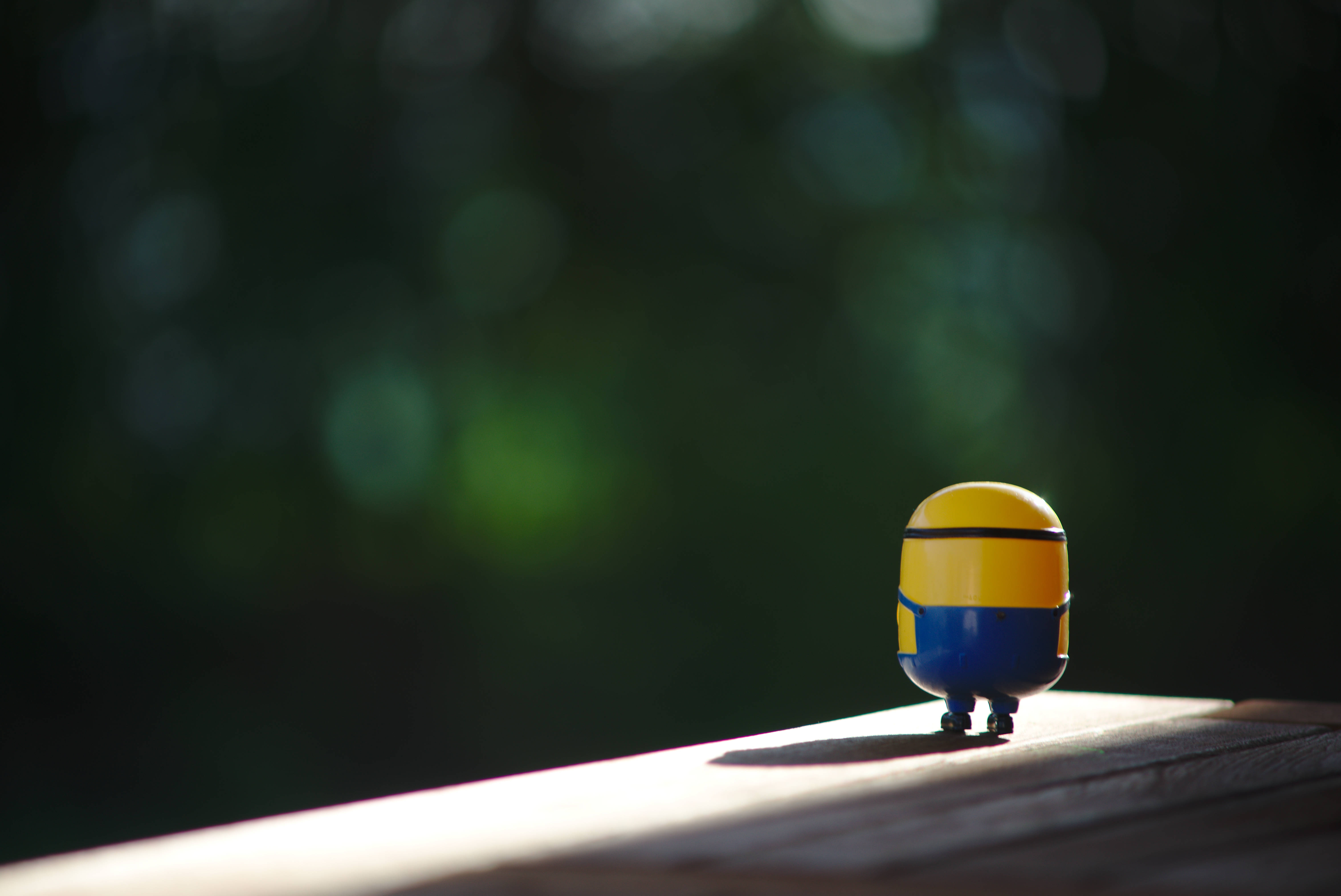 Minion, yellow and blue, sunlit wooden surface, 5K Desktop Wallpaper