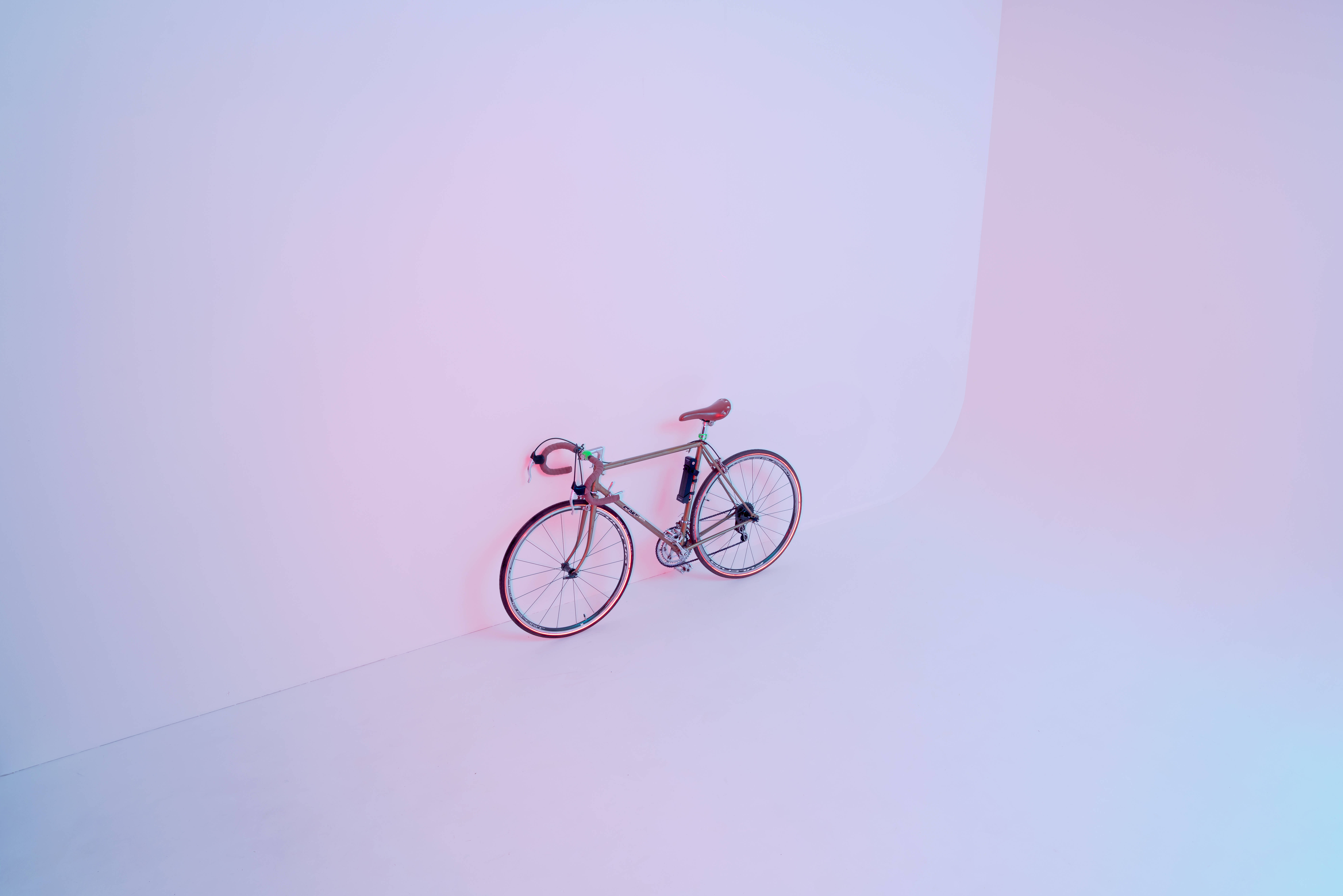 road bicycle, minimalist studio corner, soft pink and blue gradient lighting, 8K Desktop Wallpaper