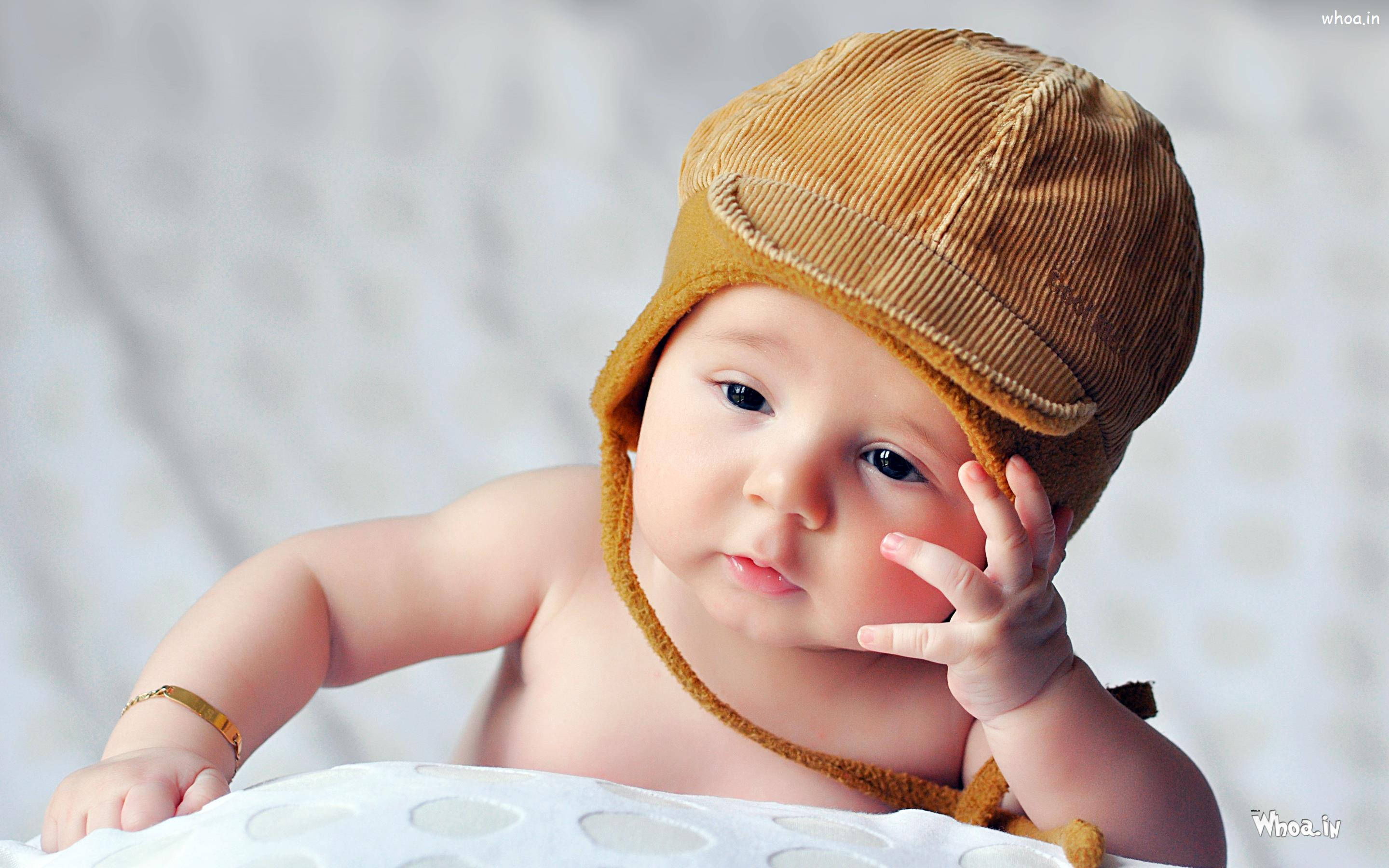 cute sad baby, brown corduroy hat, white textured blanket, 2K Desktop Wallpaper