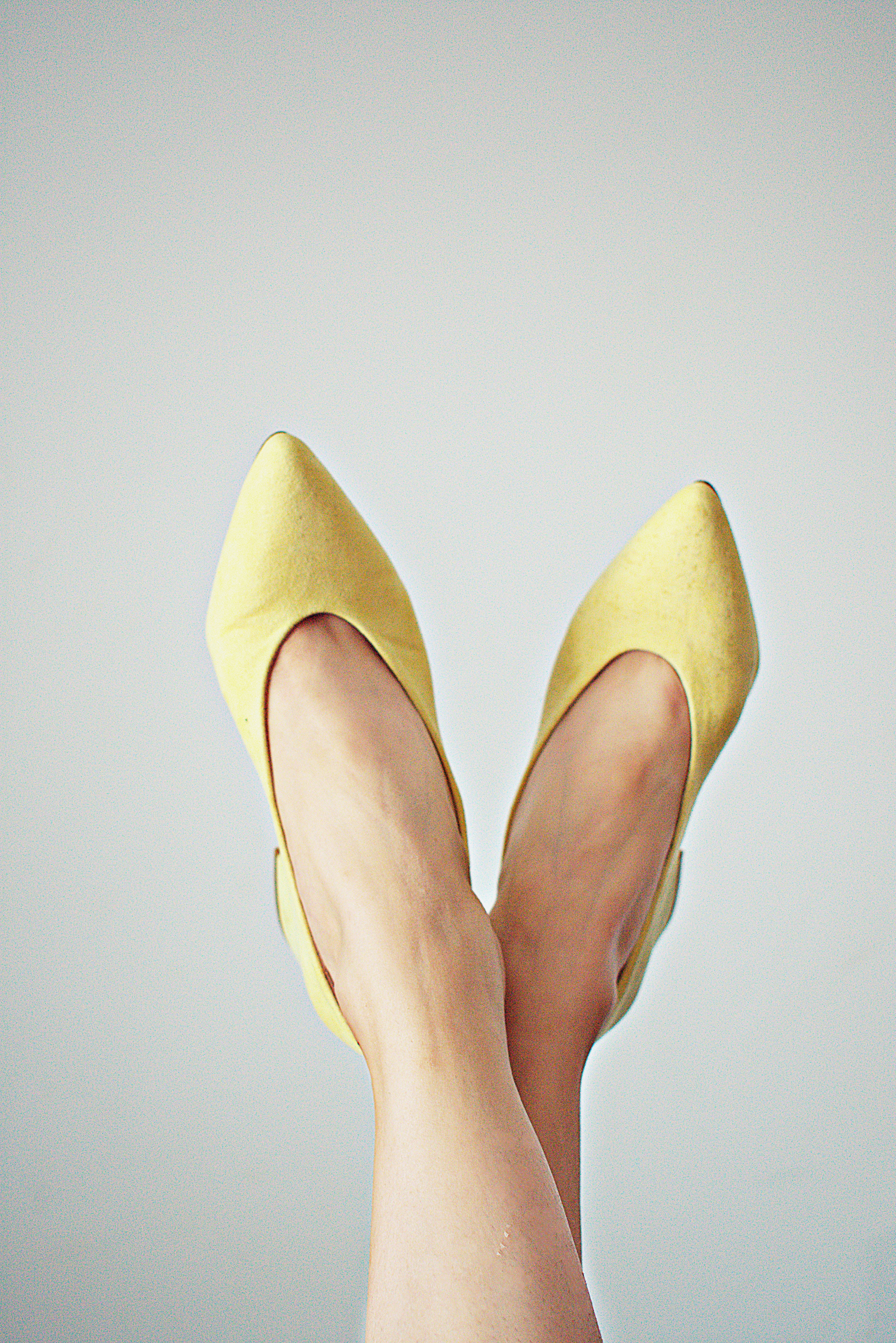 pale yellow, pointed-toe flats, light gray background, 5K Phone Wallpaper