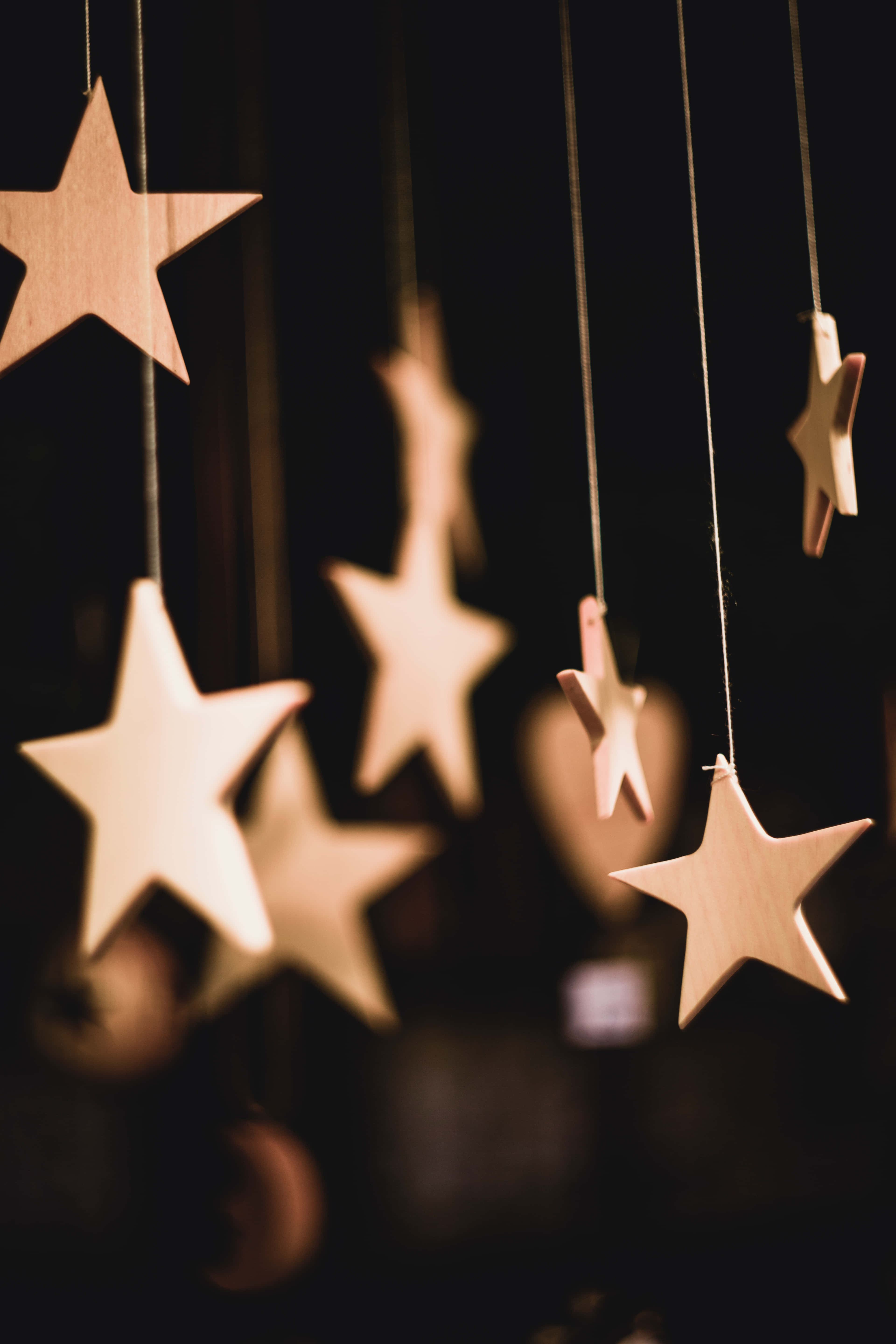 hanging cute stars cardboard cutout, warm wooden stars, dim light, 5K Phone Wallpaper
