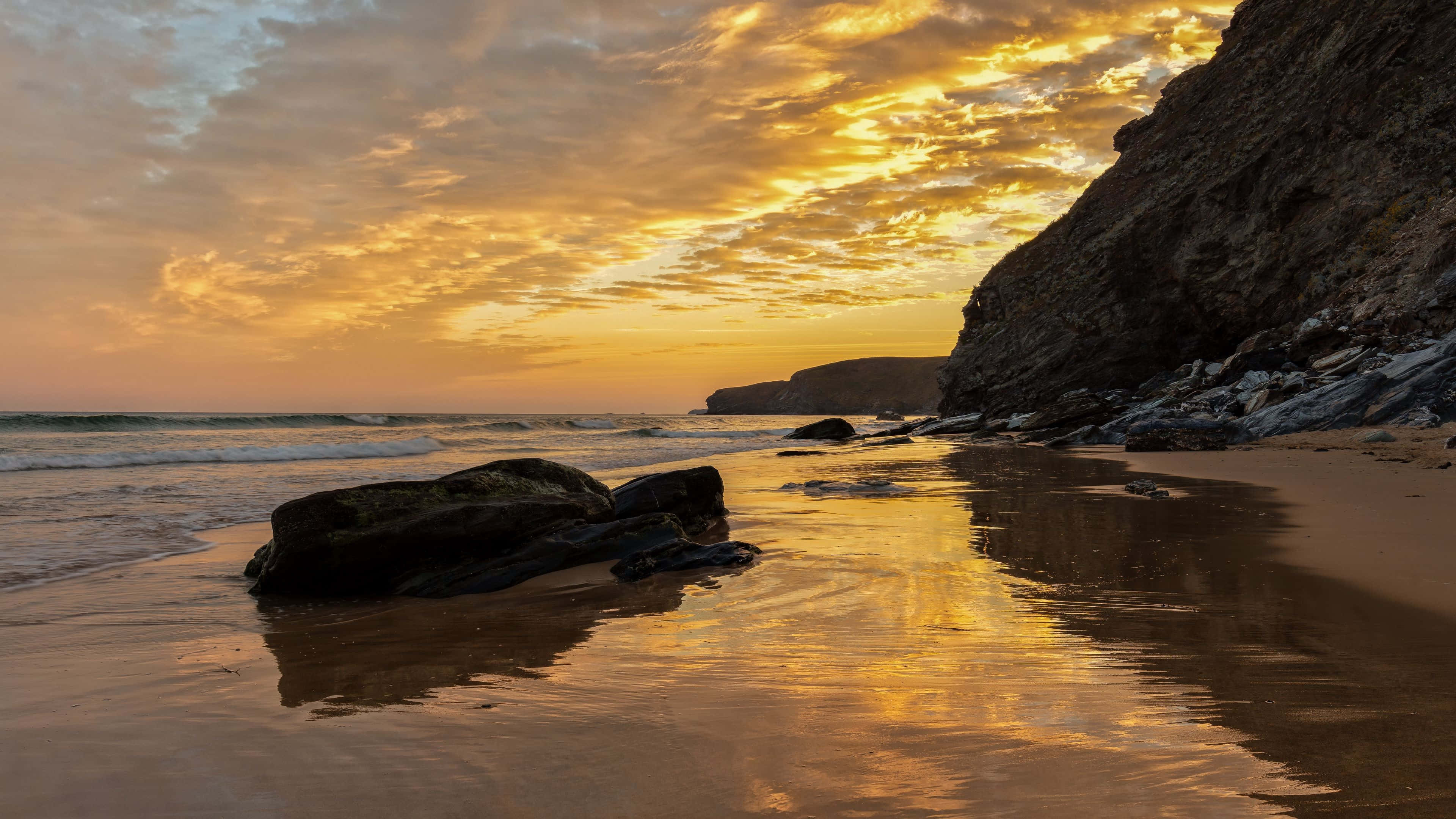 Golden sunset, wet sand, rugged cliffs, 4K Desktop Wallpaper