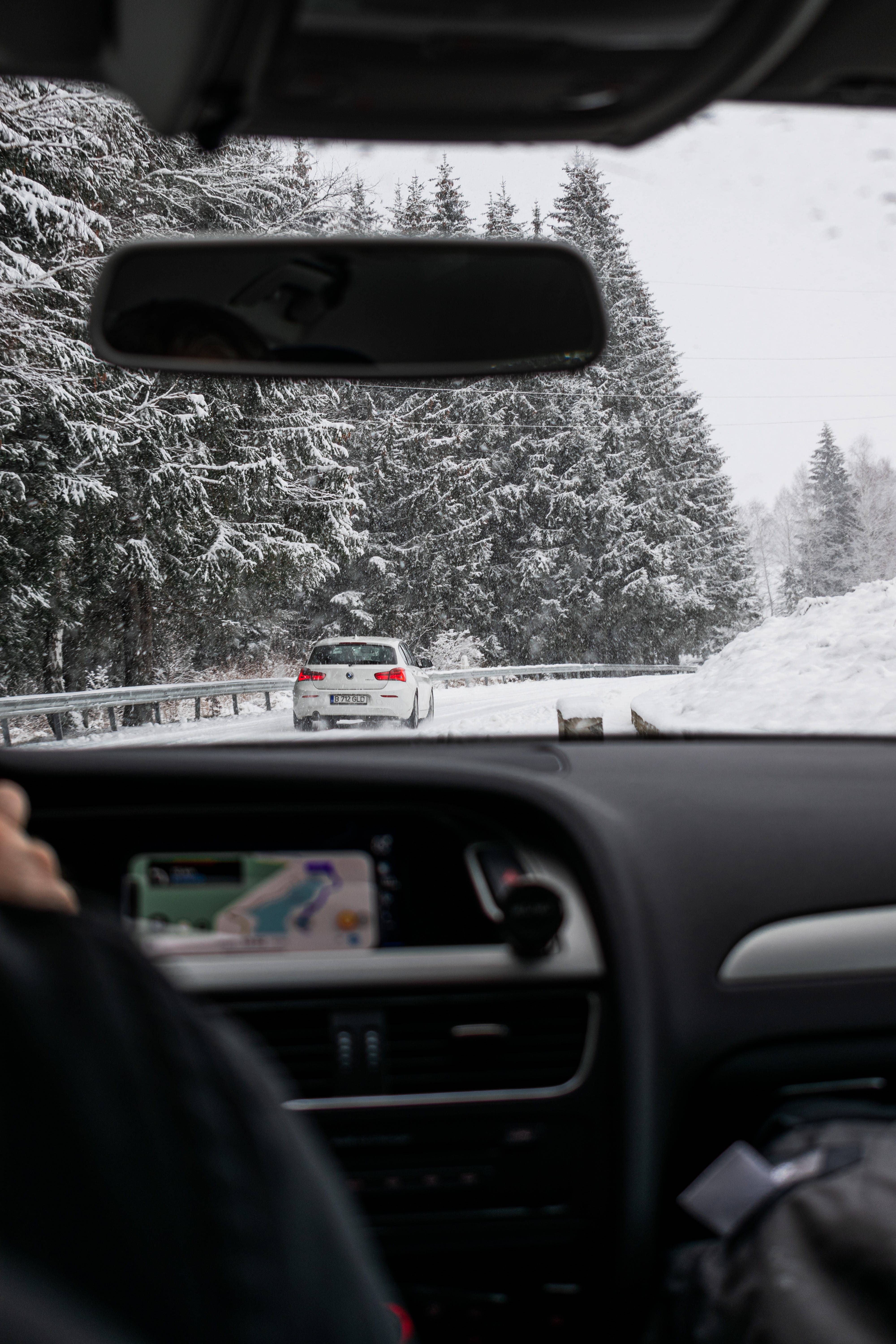 snowy forest road, white car, snow-covered pine trees, 5K Phone Wallpaper