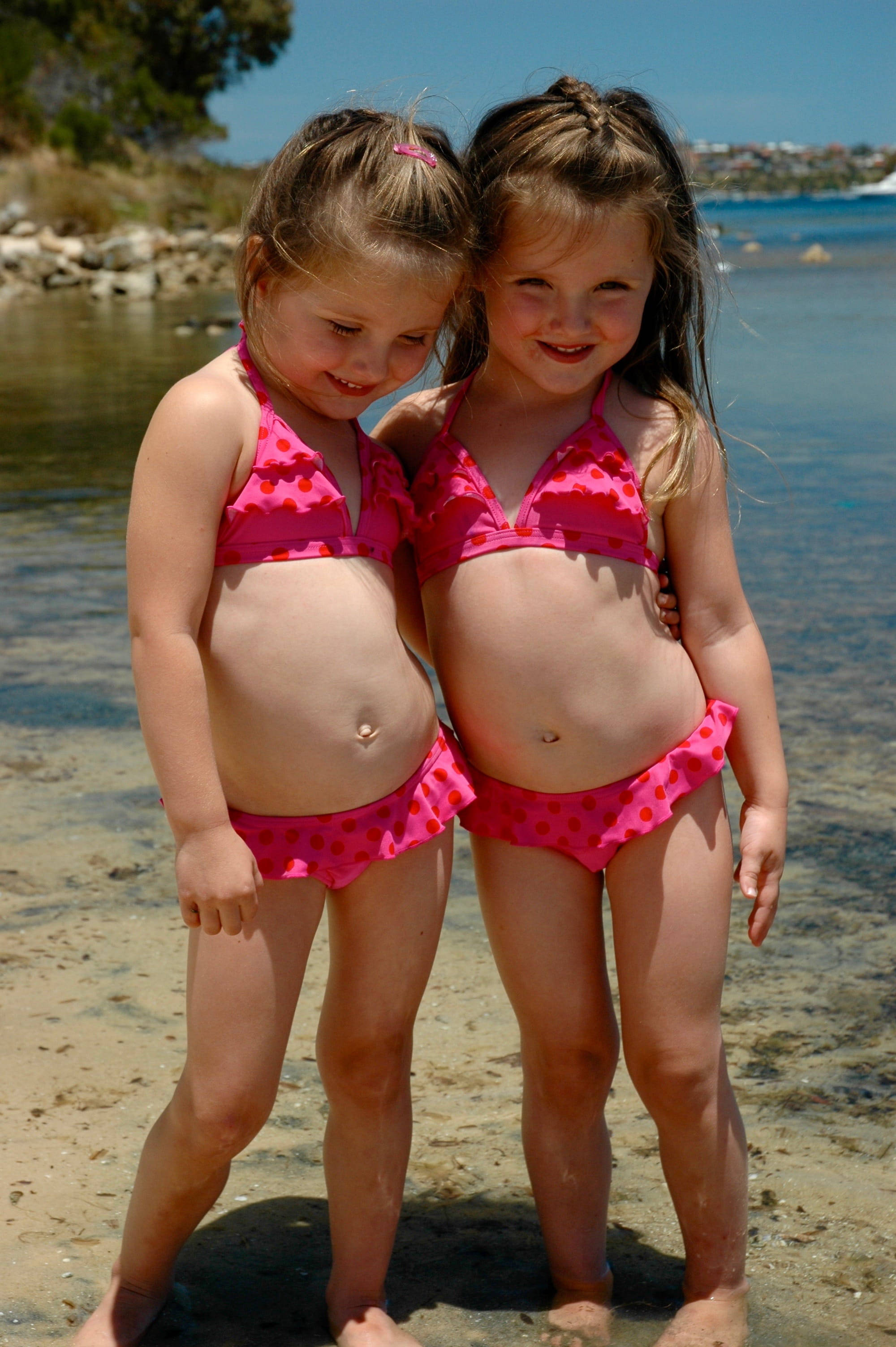 girl sister, pink polka-dot bikinis, sunlit beach sand, 2K Phone Wallpaper