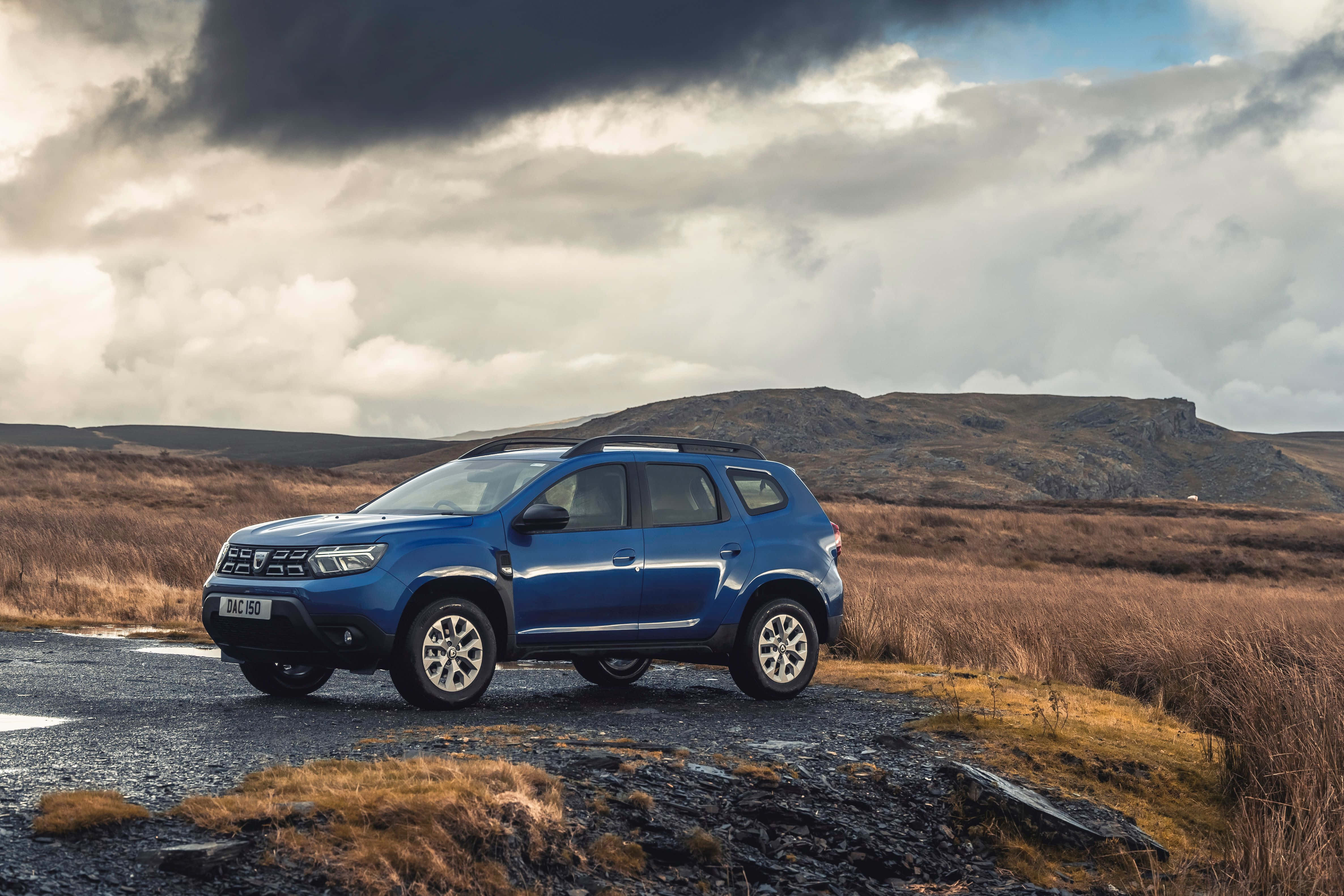 Blue Dacia Duster, gravel road, golden grasslands, 4K Desktop Wallpaper