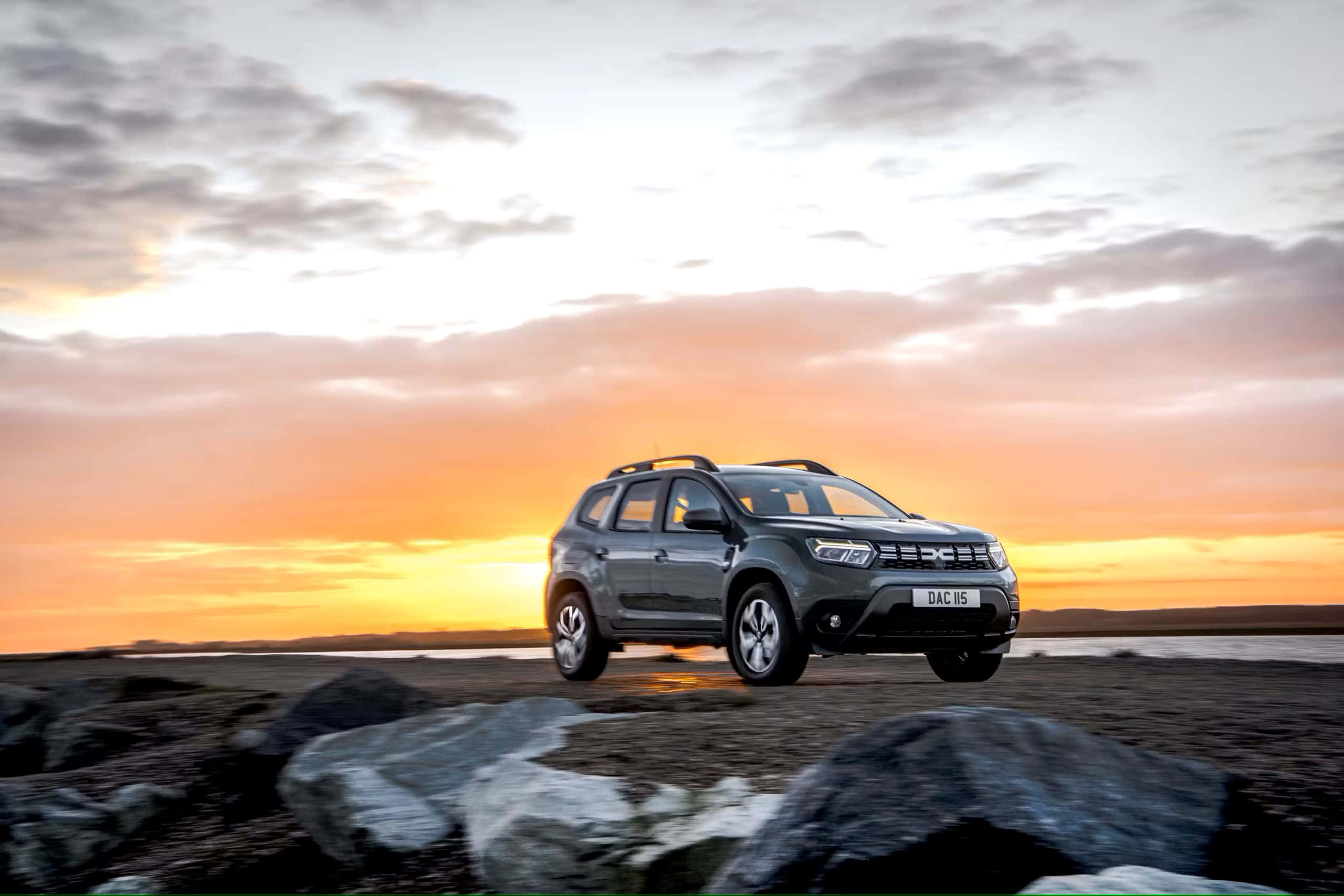 Dacia Duster, sunset, rocky shoreline, 2K Desktop Wallpaper