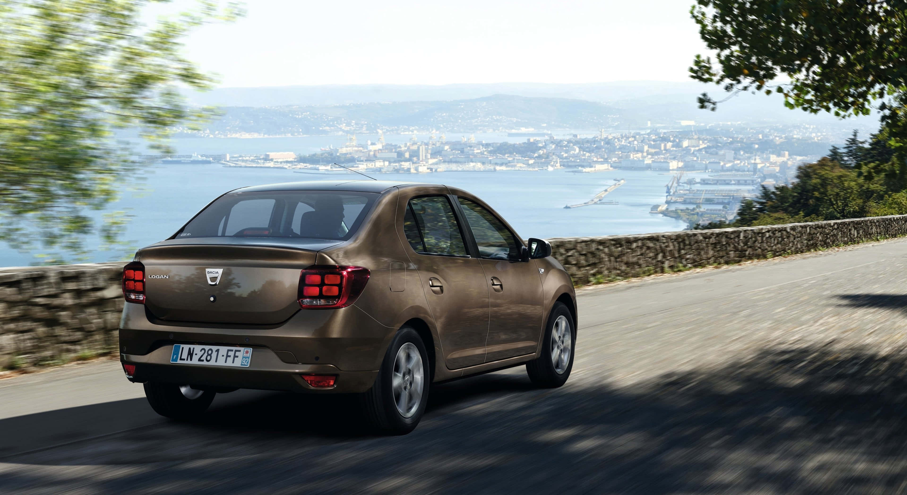 Dacia Logan, brown sedan, coastal road, 2K Desktop Wallpaper