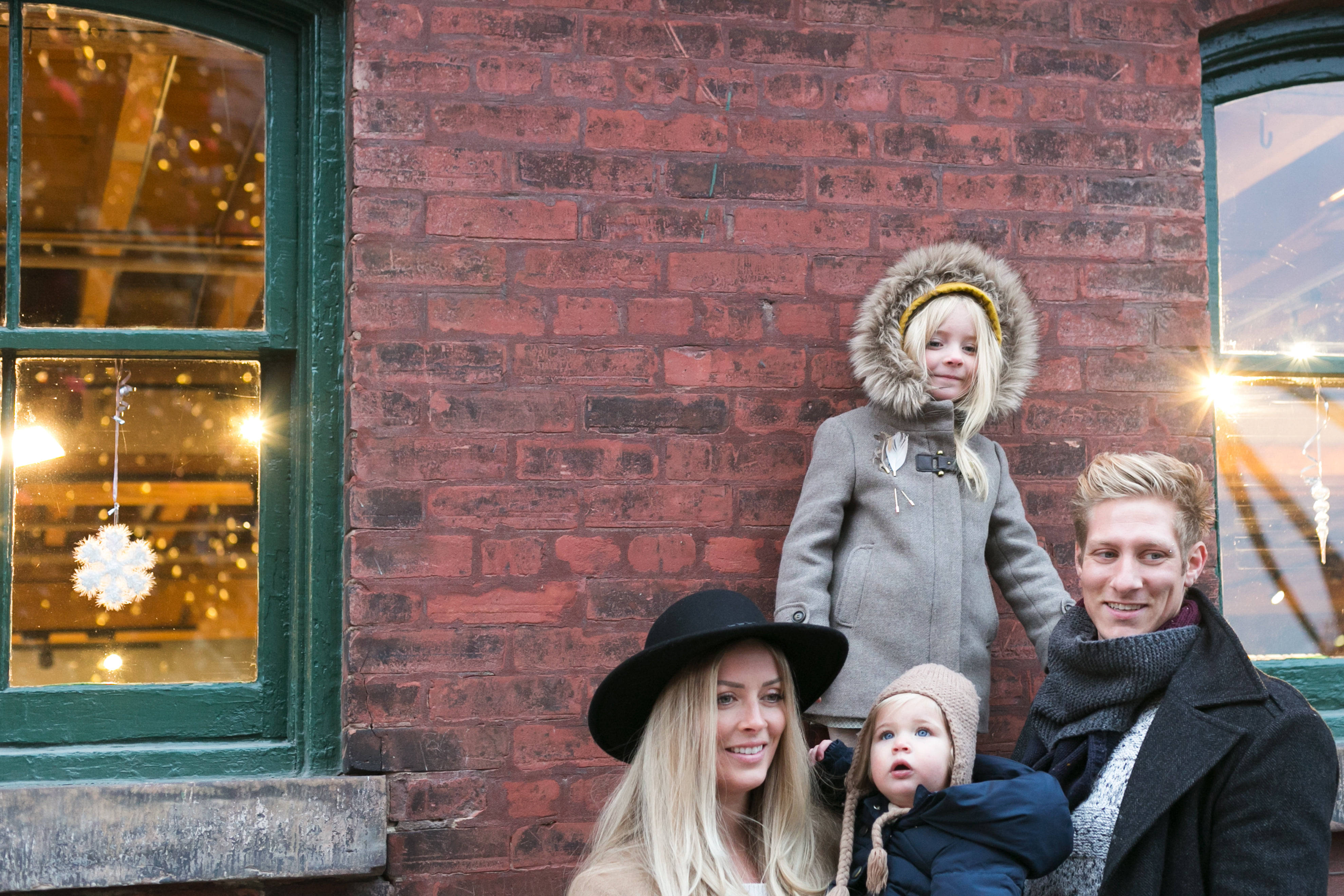 family of four, red brick wall, festive lights, 4K Desktop Wallpaper