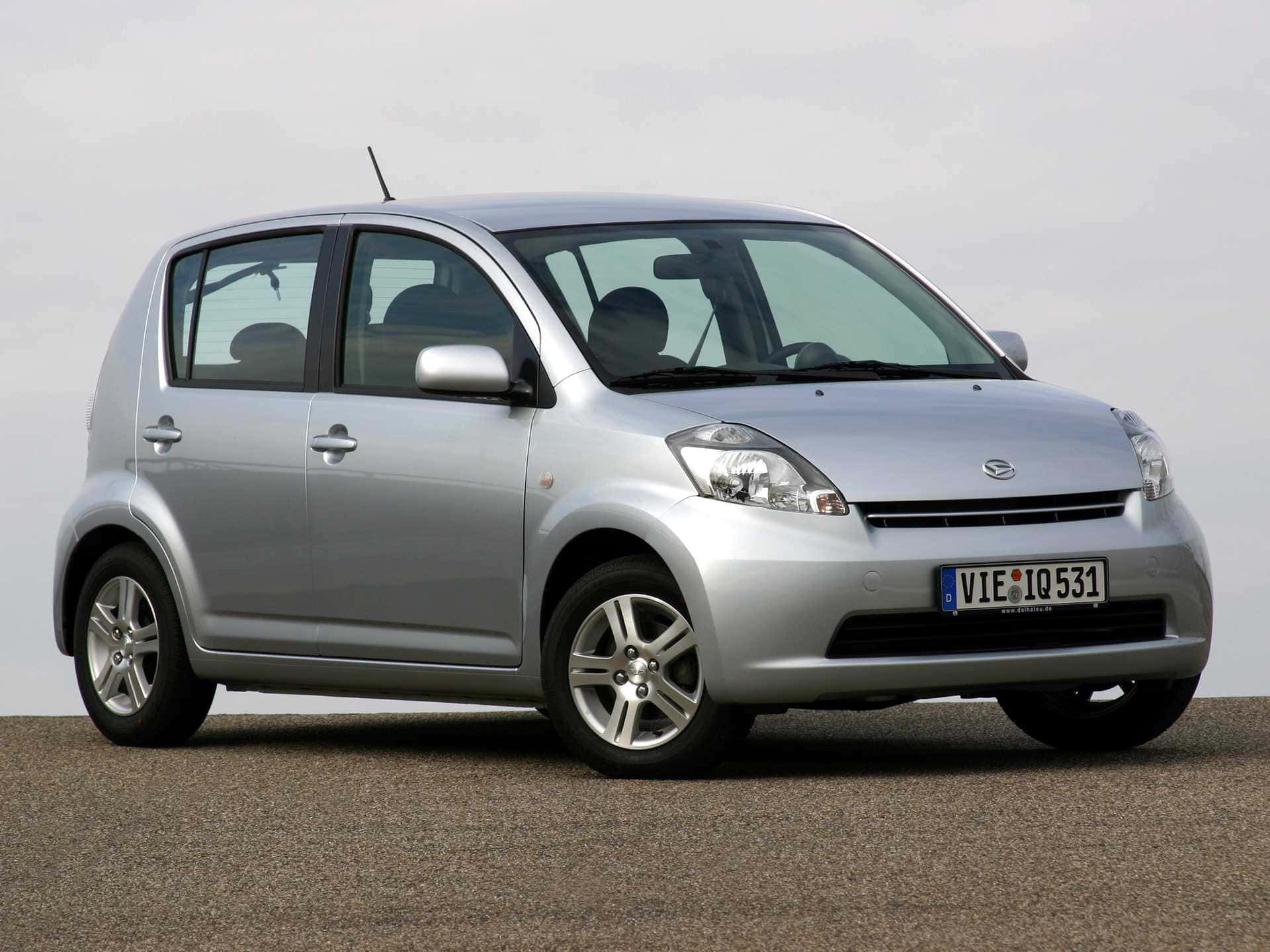 Daihatsu Sirion, sleek silver compact car, parked on gravel, Full HD Desktop Wallpaper
