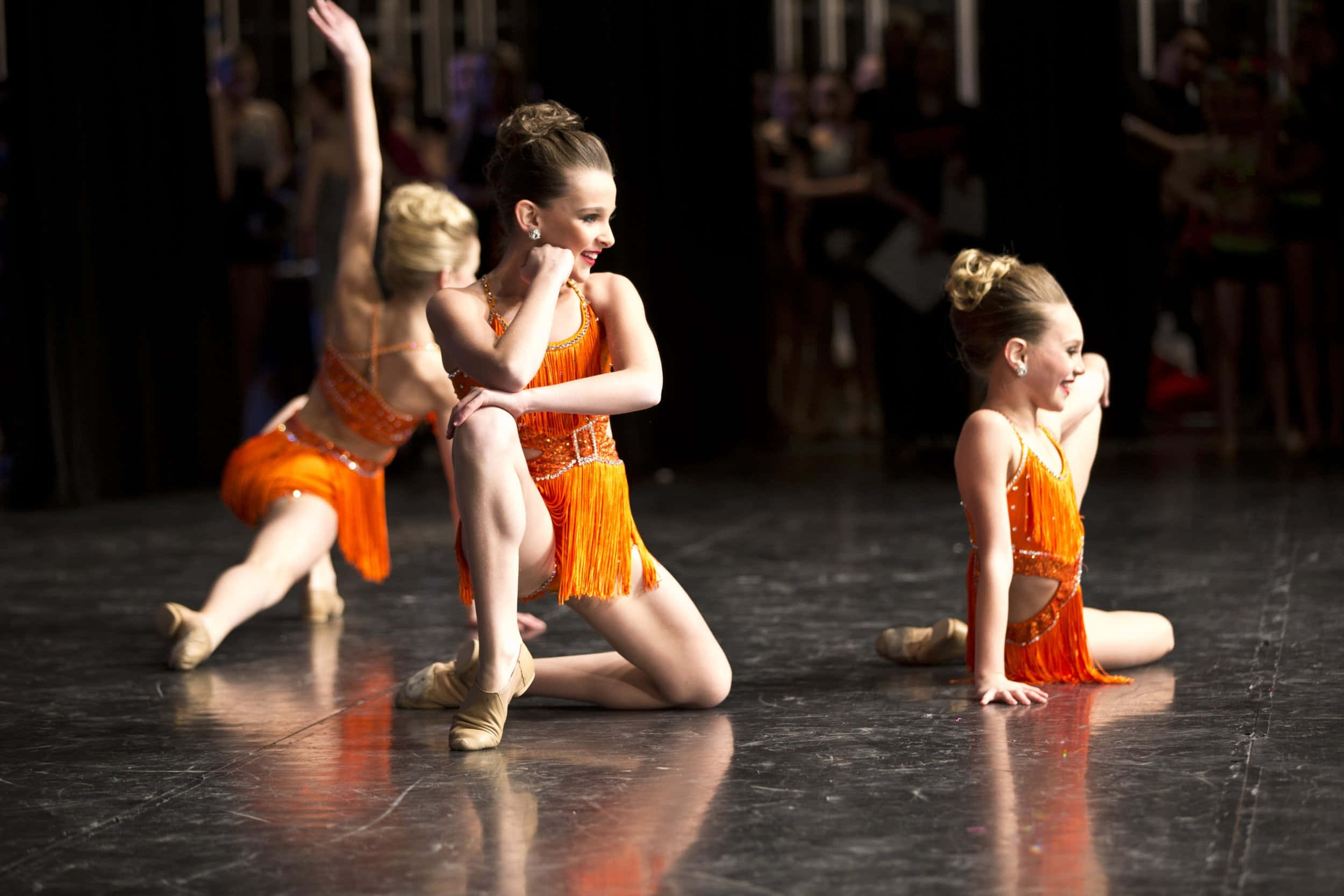 young dancers, vibrant orange fringe costumes, reflective stage, Full HD Desktop Wallpaper