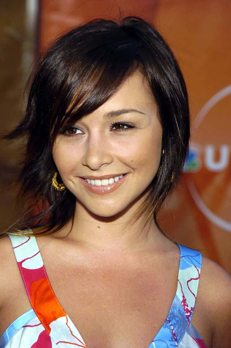 Danielle Harris, orange backdrop, colorful patterned top, SD Phone Wallpaper