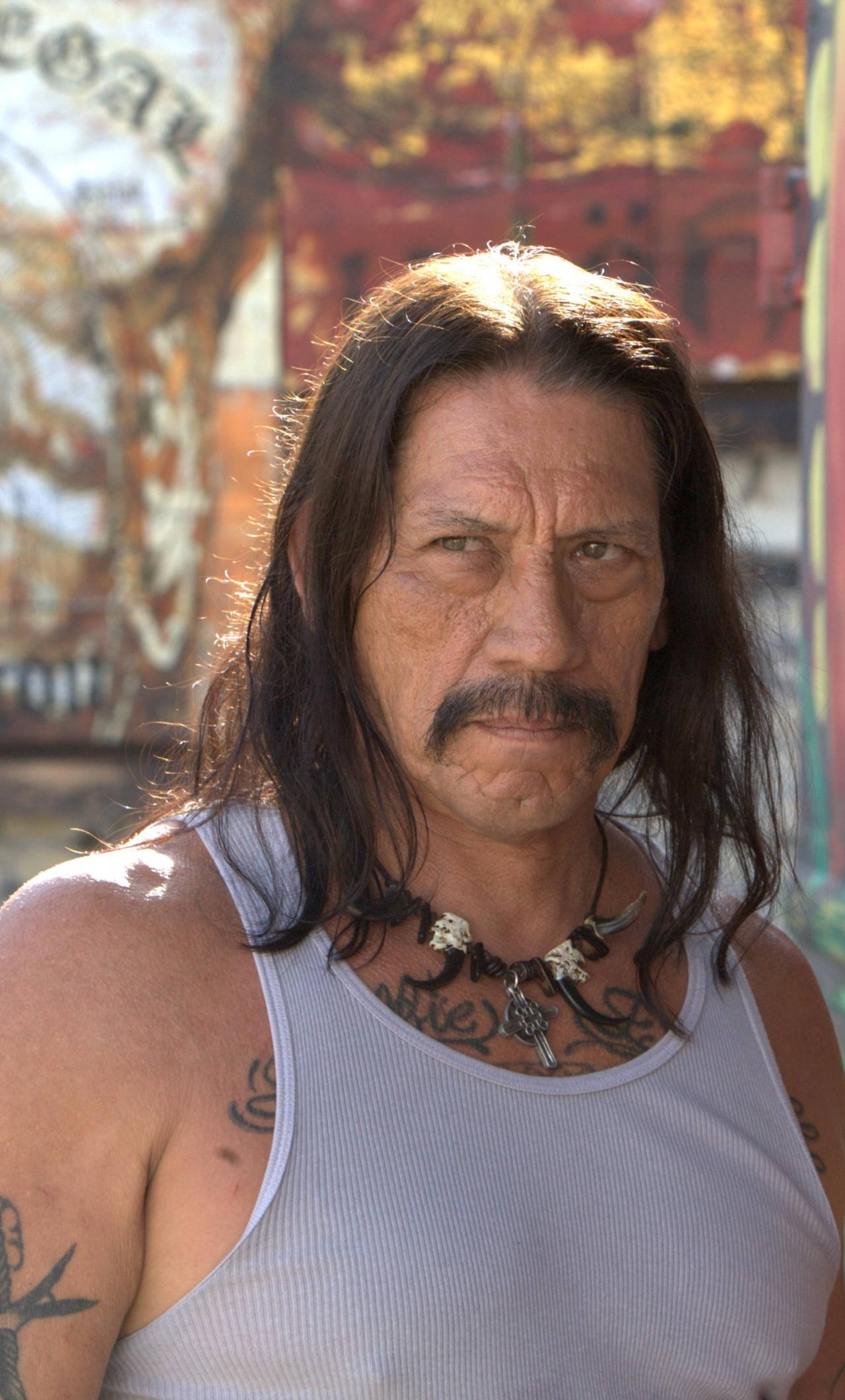 Danny Trejo, white tank top, graffiti-covered urban wall, Full HD Phone Wallpaper