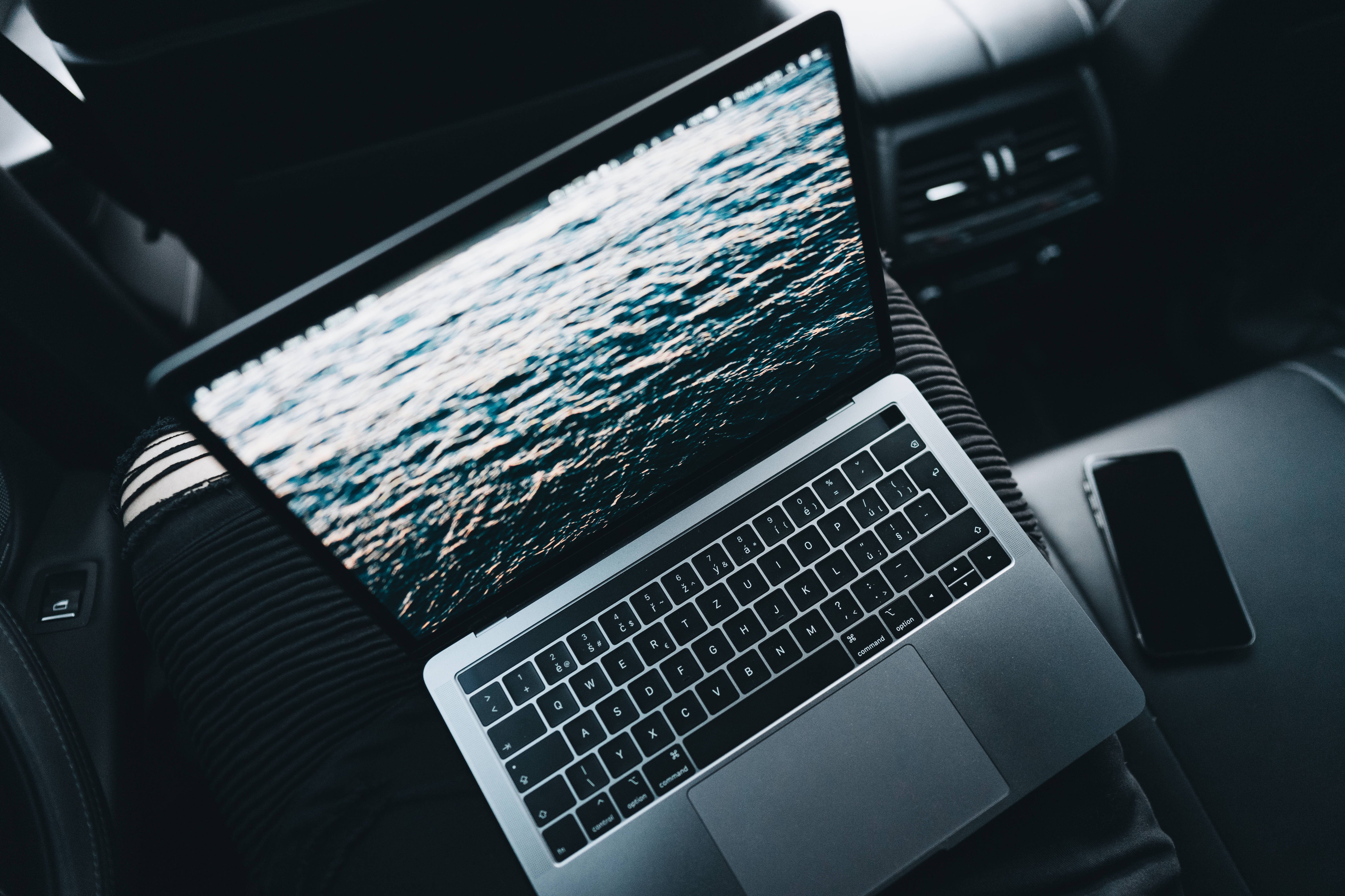 silver laptop, rippling ocean scene, car, 5K Desktop Wallpaper