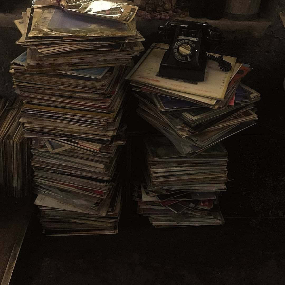 vintage black rotary phone, chaotic stack of aged magazines, dimly lit, SD Desktop Wallpaper