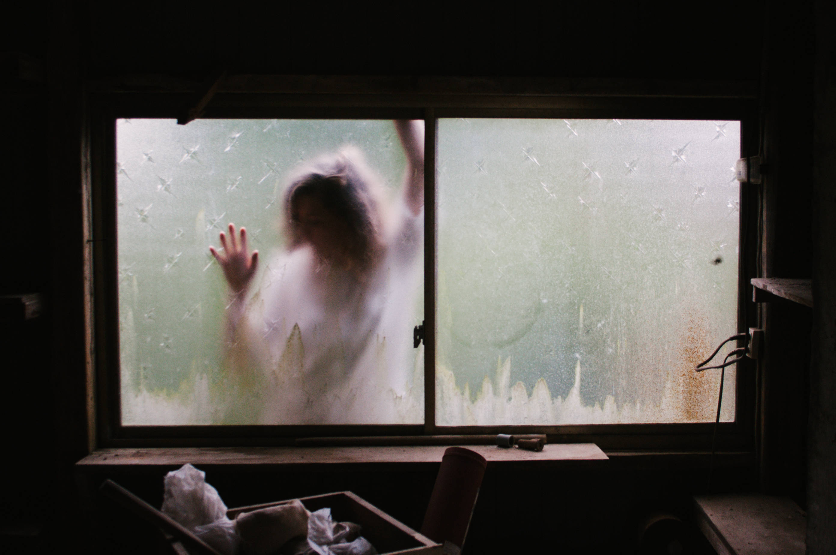 spooky woman, rain-streaked window, dimly lit room, 2K Desktop Wallpaper