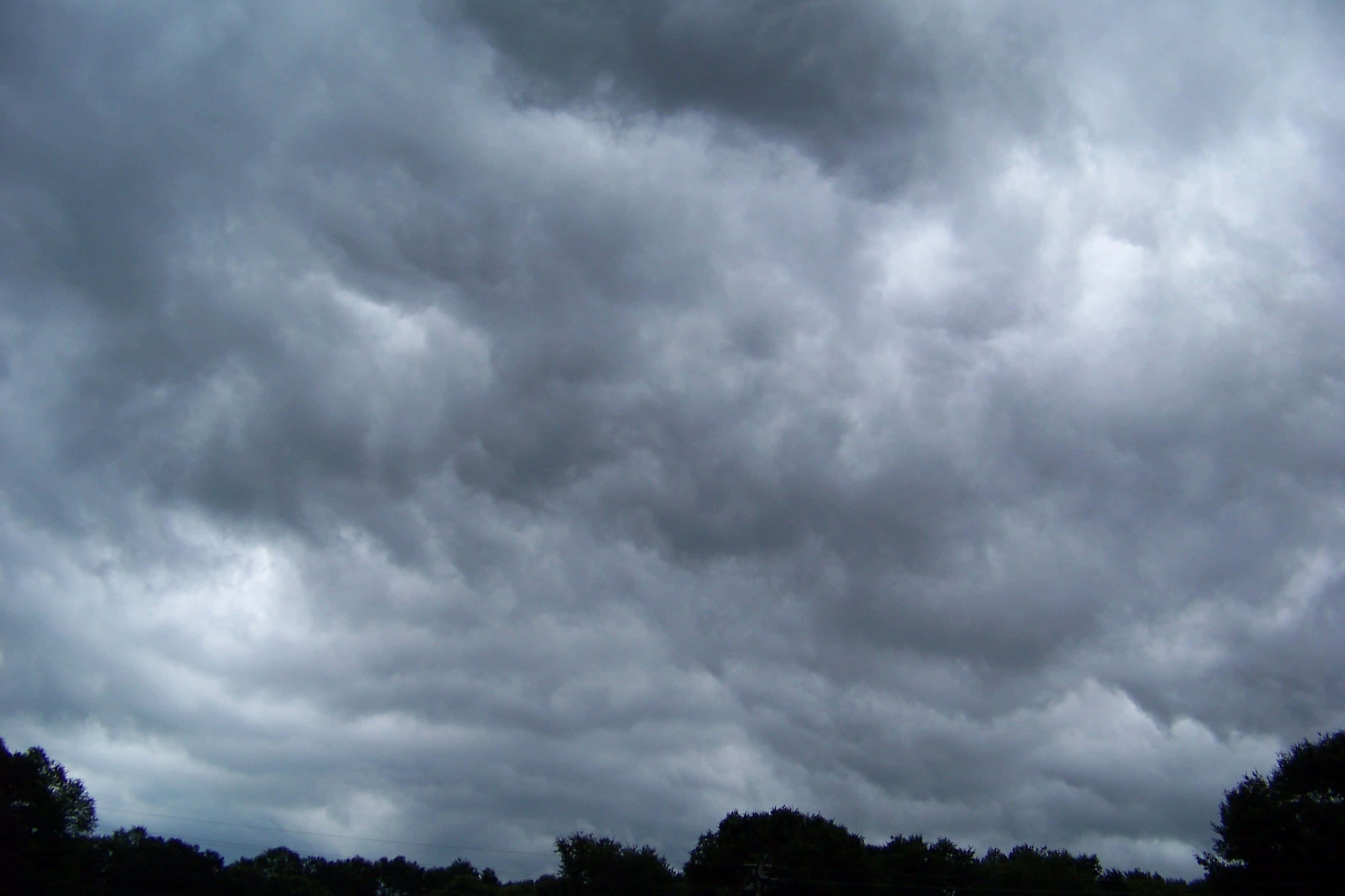 Dark Heaven, storm clouds, silhouetted treeline, 2K Desktop Wallpaper