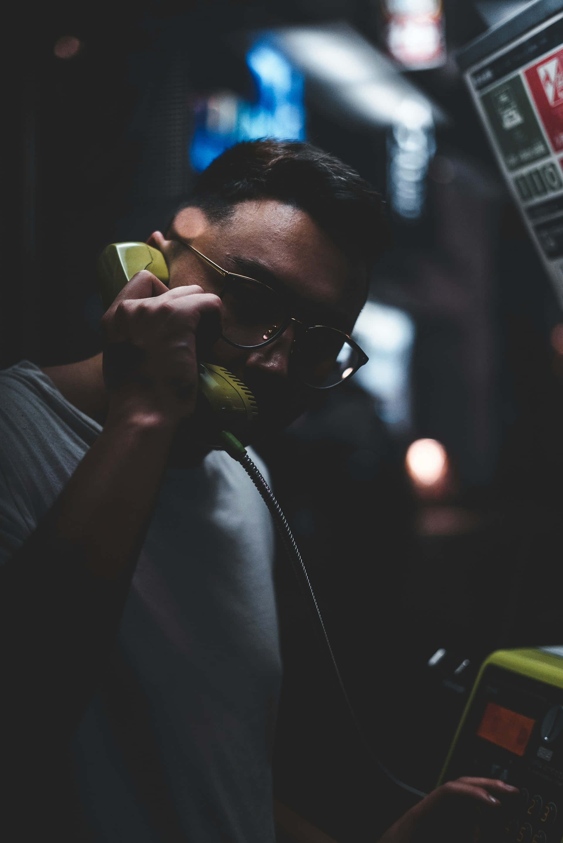 vintage yellow telephone, glasses, dimly lit urban setting, 2K Phone Wallpaper