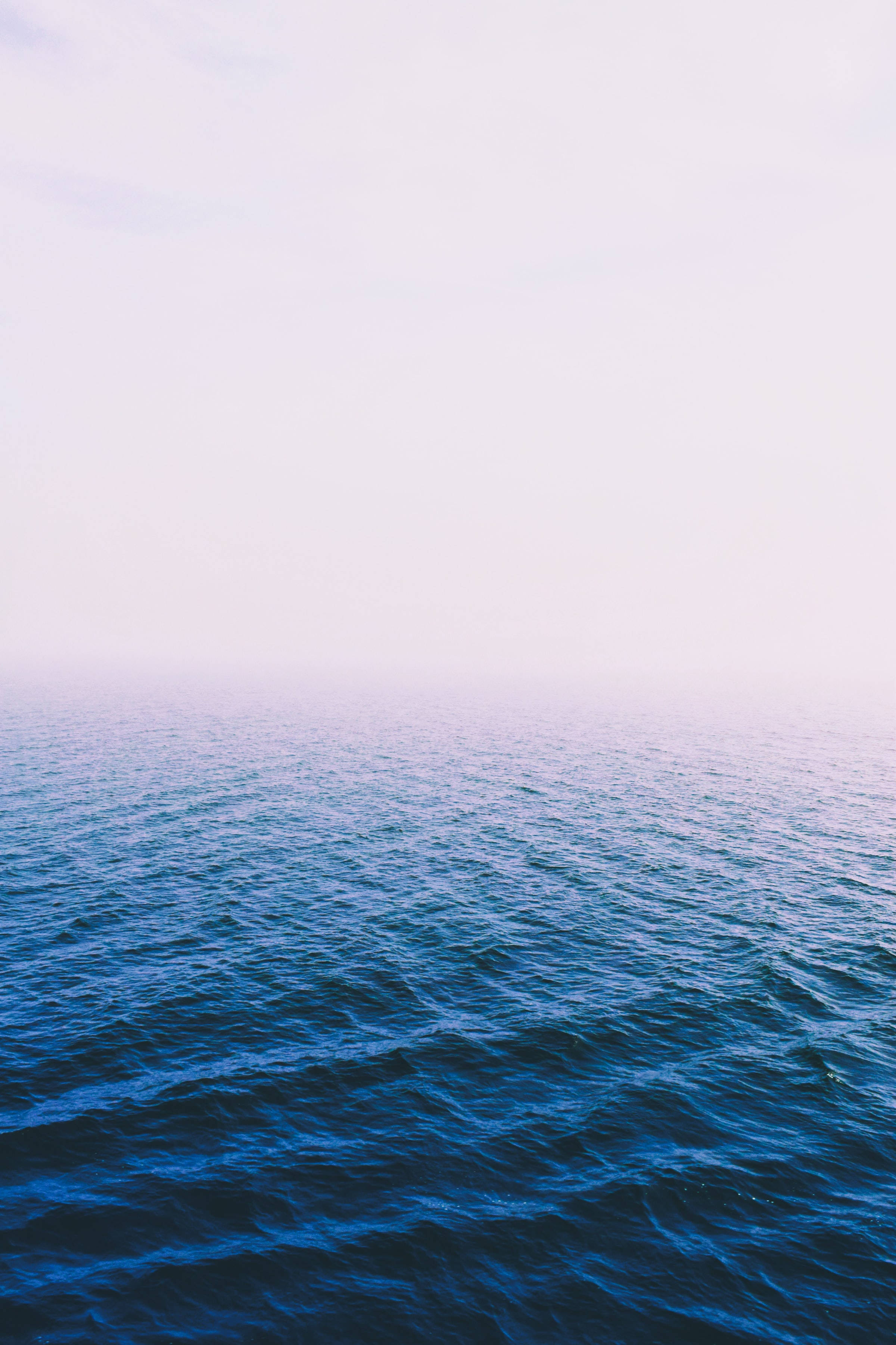 Calm Dark Blue Ocean, vast ocean, hazy pink sky, 2K Phone Wallpaper