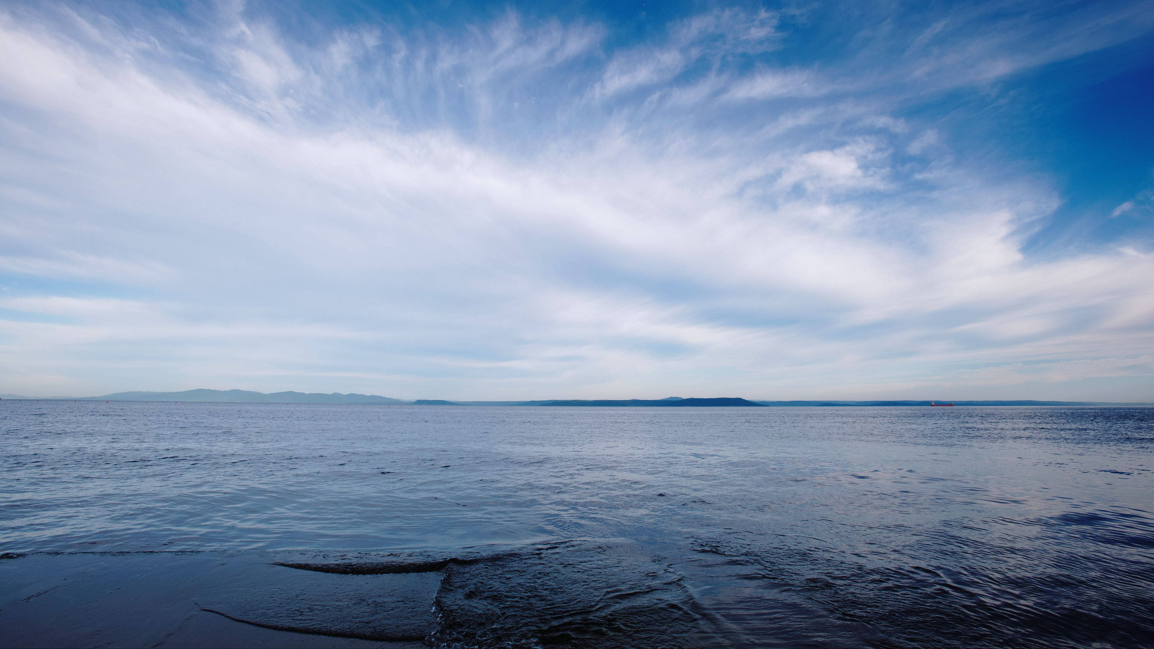 melancholic dark sea horizon, vast calm ocean, distant hazy islands, 4K Desktop Wallpaper